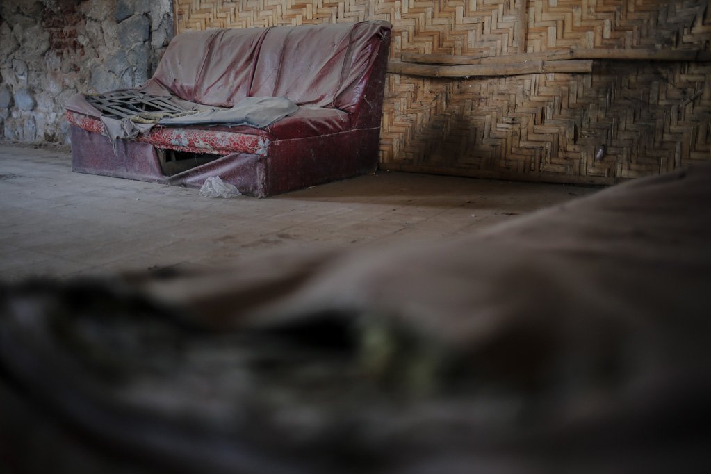 Sofa rusak dipenuhi debu berada di sudut bangunan bekas Stasiun Panarukan, Situbondo, Jawa Timur, Senin, (16/8/2021). Di dalam bangunan yang memiliki riwayat sejarah pertumbuhan ekonomi di Timur Pulau Jawa yang kini dijadikan gudang bongkar muat ikan tangkapan nelayan setempat dan seolah terlupakan.