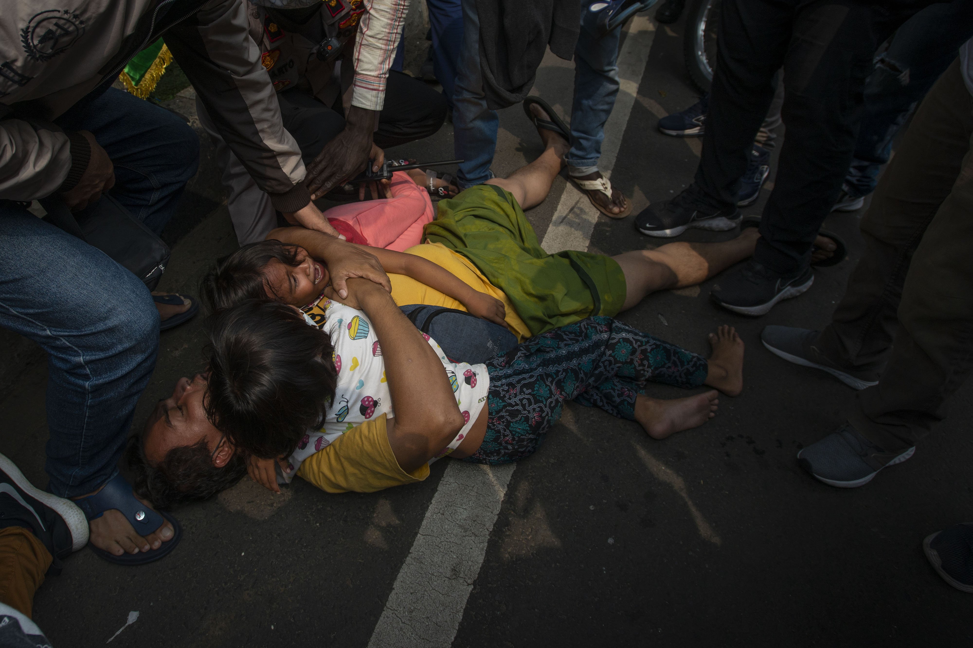 Pencari suaka asal Afghanistan berbaring dengan anaknya di jalan saat polisi membubarkan unjuk rasa di depan Kantor Komisi Tinggi PBB untuk Pengungsi (UNHCR), Kebon Sirih, Jakarta, Selasa (24/8/2021). Aksi menuntut kejelasan status penempatan pencari suaka di negara tujuan tersebut dibubarkan polisi karena memicu kerumunan di tengah pelaksanaan Pemberlakuan Pembatasan Kegiatan Masyarakat (PPKM). ANTARA FOTO/Aditya Pradana Putra/foc.