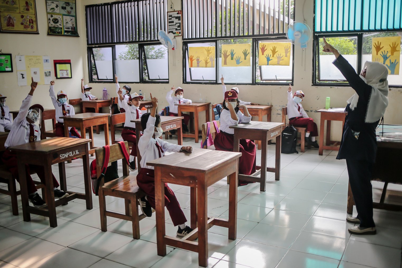 Sejumlah siswa mengikuti kegiatan Pembelajaran Tatap Muka (PTM) perdana di Sekolah Dasar Negeri (SDN) Pondok Labu 14 Pagi, Cilandak, Jakarta Selatan, Senin, (30/8/2021). Dinas Pendidikan DKI Jakarta resmi mengeluarkan petunjuk teknis sekolah tatap muka yang akan digelar mulai hari ini. Aturan petunjuk teknis itu tertuang dalam Keputusan Kepala Dinas Pendidikan DKI Jakarta Nomor 882 Tahun 2021 tentang teknis pembelajaran tatap muka terbatas di masa pandemi Covid-19.\r\n\r\n