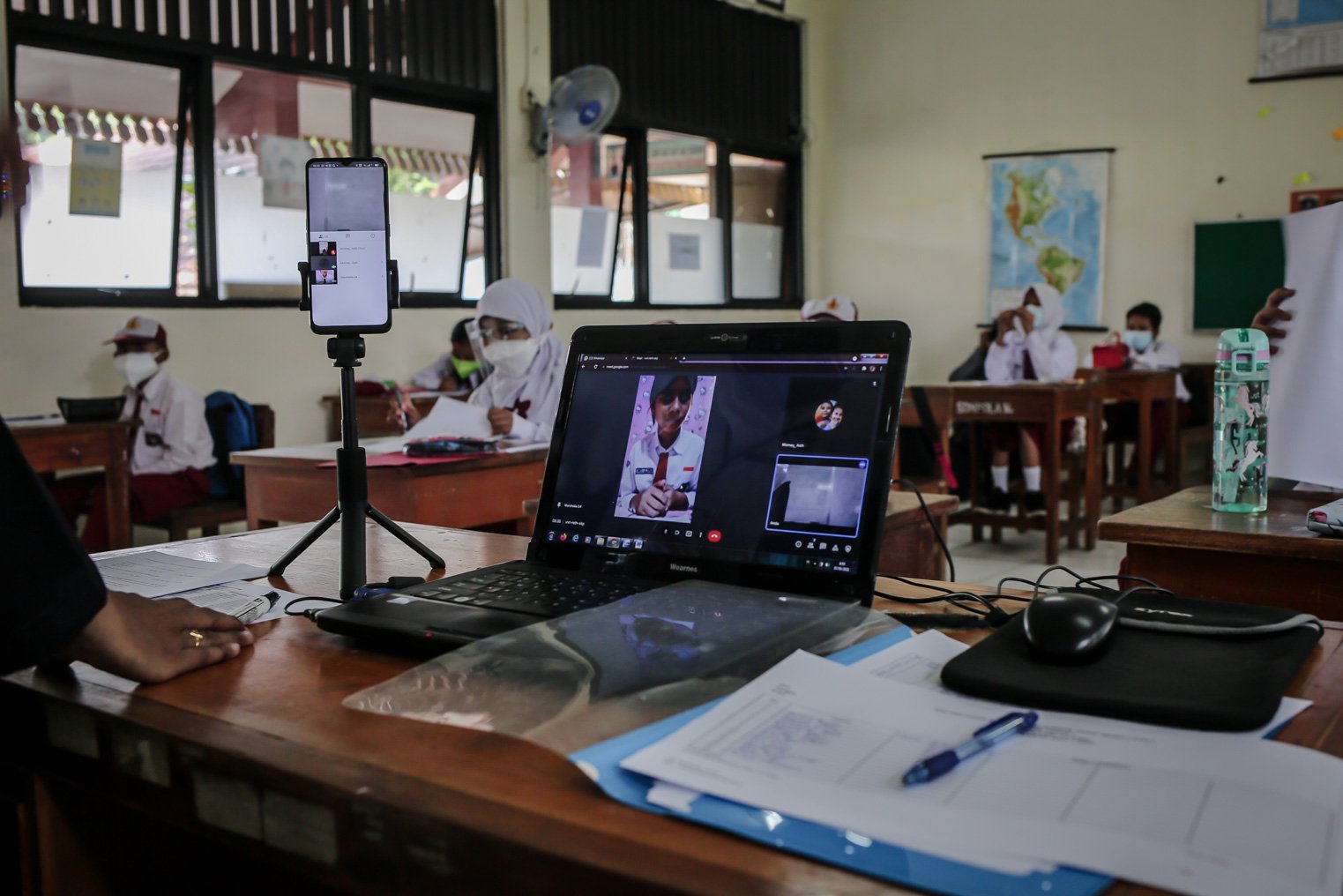 Sejumlah siswa mengikuti kelas secara virtual saat kegiatan Pembelajaran Tatap Muka (PTM) perdana di Sekolah Dasar Negeri (SDN) Pondok Labu 14 Pagi, Cilandak, Jakarta Selatan, Senin, (30/8/2021). Setiap sekolah yang menggelar tatap muka harus melalui asesmen dari Dinas Pendidikan DKI Jakarta. Asesmen itu digunakan untuk memetakan kesiapan dan menjadi pertimbangan apakah sekolah bisa membuka proses belajar tatap muka selama pandemi Covid-19.\r\n\r\n