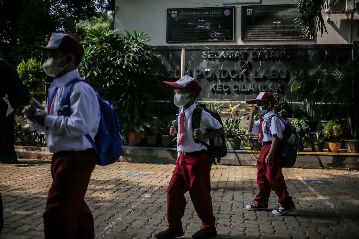 Sejumlah siswa berjalan dengan menerapkan protokol kesehatan saat mengikuti kegiatan Pembelajaran Tatap Muka (PTM) perdana di Sekolah Dasar Negeri (SDN) Pondok Labu 14 Pagi, Cilandak, Jakarta Selatan, Senin, (30/8/2021). 