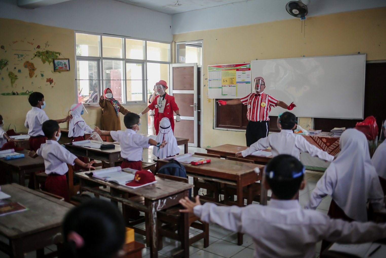 Seniman Aku Badut Indonesia (ABI) menghibur siswa sebelum membagikan masker di SDN 03 Citayam, Kabupaten Bogor, Jawa Barat, Senin (6/9/2021). Kegiatan aksi kampanye tersebut tentang protokol kesehatan serta membagikan masker kepada anak-anak sekolah yang menggelar Pembelajaran Tatap Muka (PTM)
