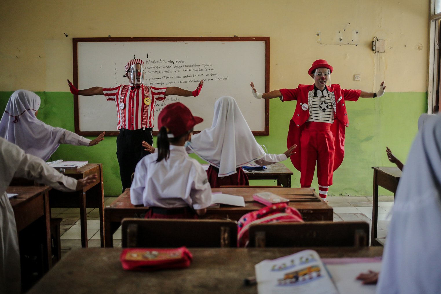 Seniman Aku Badut Indonesia (ABI) memberikan edukasi 5M kepada siswa di SDN 03 Citayam, Kabupaten Bogor, Jawa Barat, Senin (6/9/2021). Kegiatan aksi kampanye tersebut tentang protokol kesehatan serta membagikan masker kepada anak-anak sekolah yang menggelar Pembelajaran Tatap Muka (PTM).
