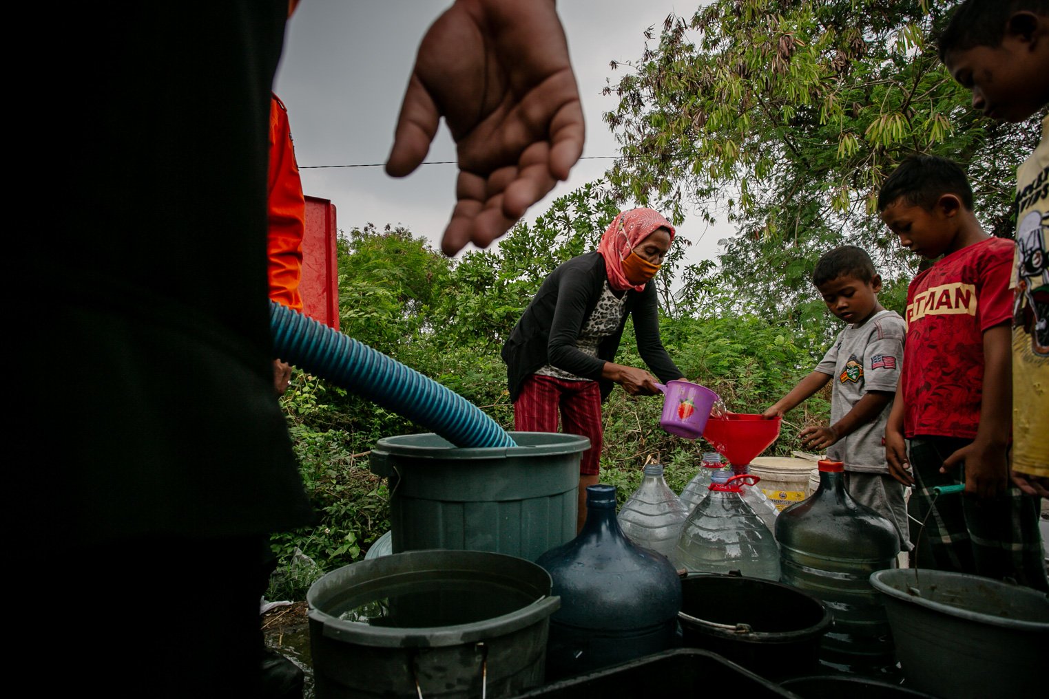 Sejumlah warga mengantre untuk mendapatkan air bersih yang disalurkan Badan Penanggulangan Bencana Daerah (BPBD) Kabupaten Bekasi di Kawasan Cikarang, Kabupaten Bekasi, Jawa Barat, Rabu, (9/9/2021). Sudah hampir genap sepuluh tahun warga Desa Karang Asih terpaksa memanfaatkan aliran air Kali Cilemahabang yang keruh akibat pencemaran limbah industri sebagai sumber air utama untuk keperluan sehari-hari.
