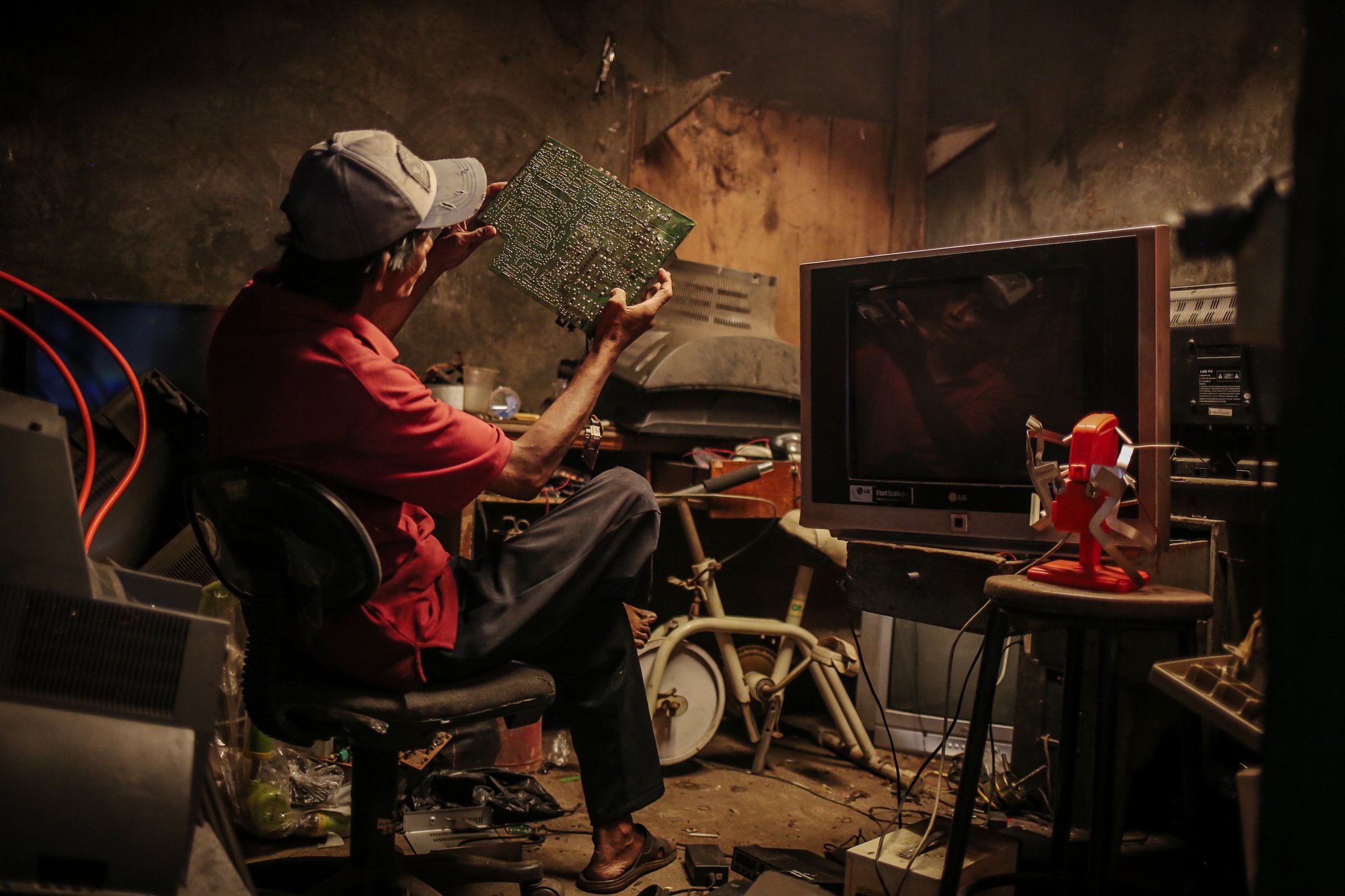 Pekerja mereparasi TV tabung di dalam ruang servis di Mal Rongsok Beji, Depok, Jawa Barat, Jumat, (17/9/2021).Untuk mengurangi peningkatan limbah eletronik Nurcholis Agi mengubahanya menjadi barang yang lebih bernilai dan bermanfaat.