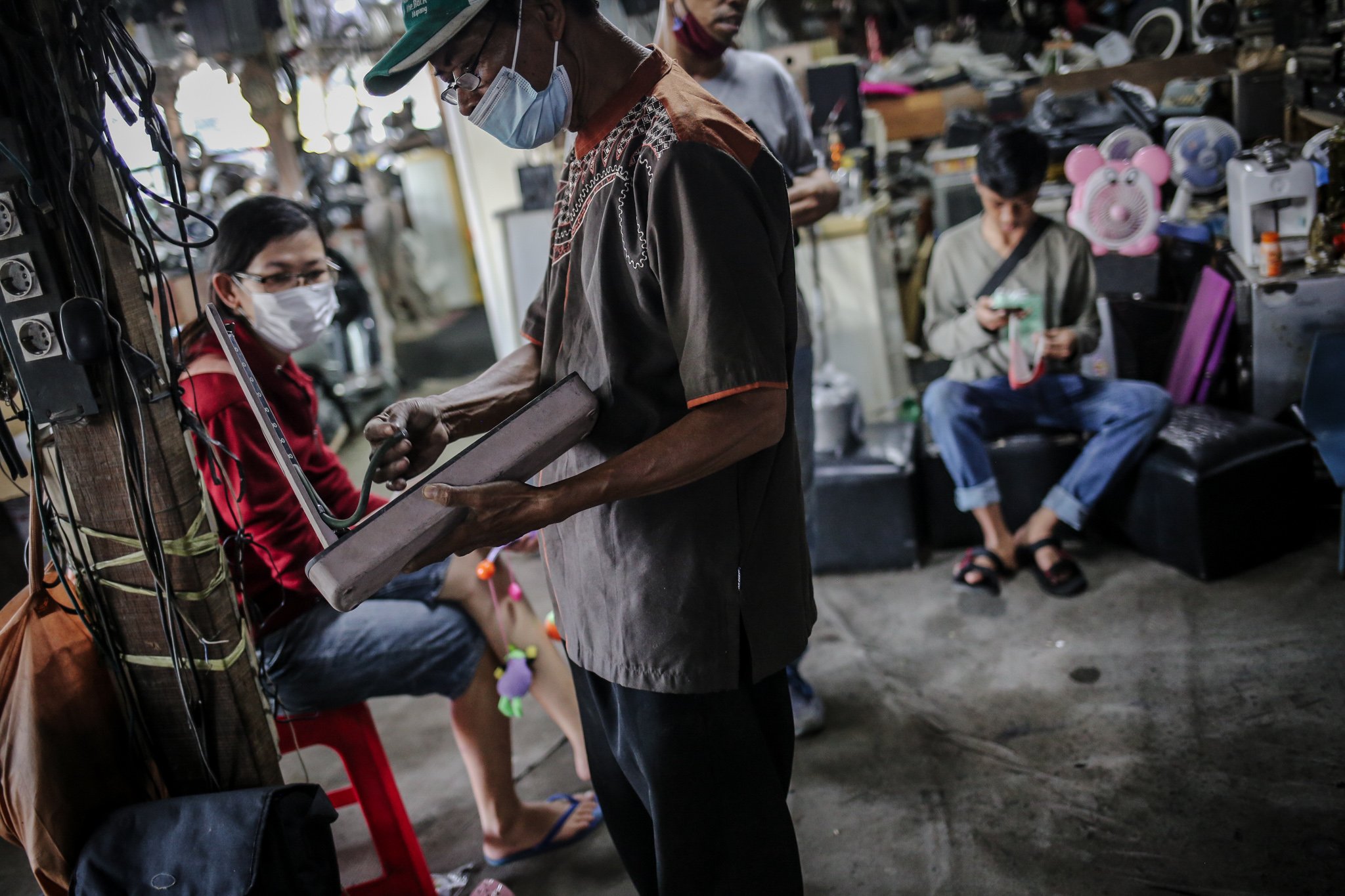 Pengunjung memilah barang bekas yang digantungkan di Mal Rongsok Beji, Depok, Jawa Barat, Jumat, (17/9/2021). Pengunjug yang datang ke Mal Rongsok tersebut tak hanya datang dari wilayah sekitar, namun hingga ke luar pulau, bahkan negara lain seperti Australia dan Jepang, untuk sekedar mencari barang-barang unik.