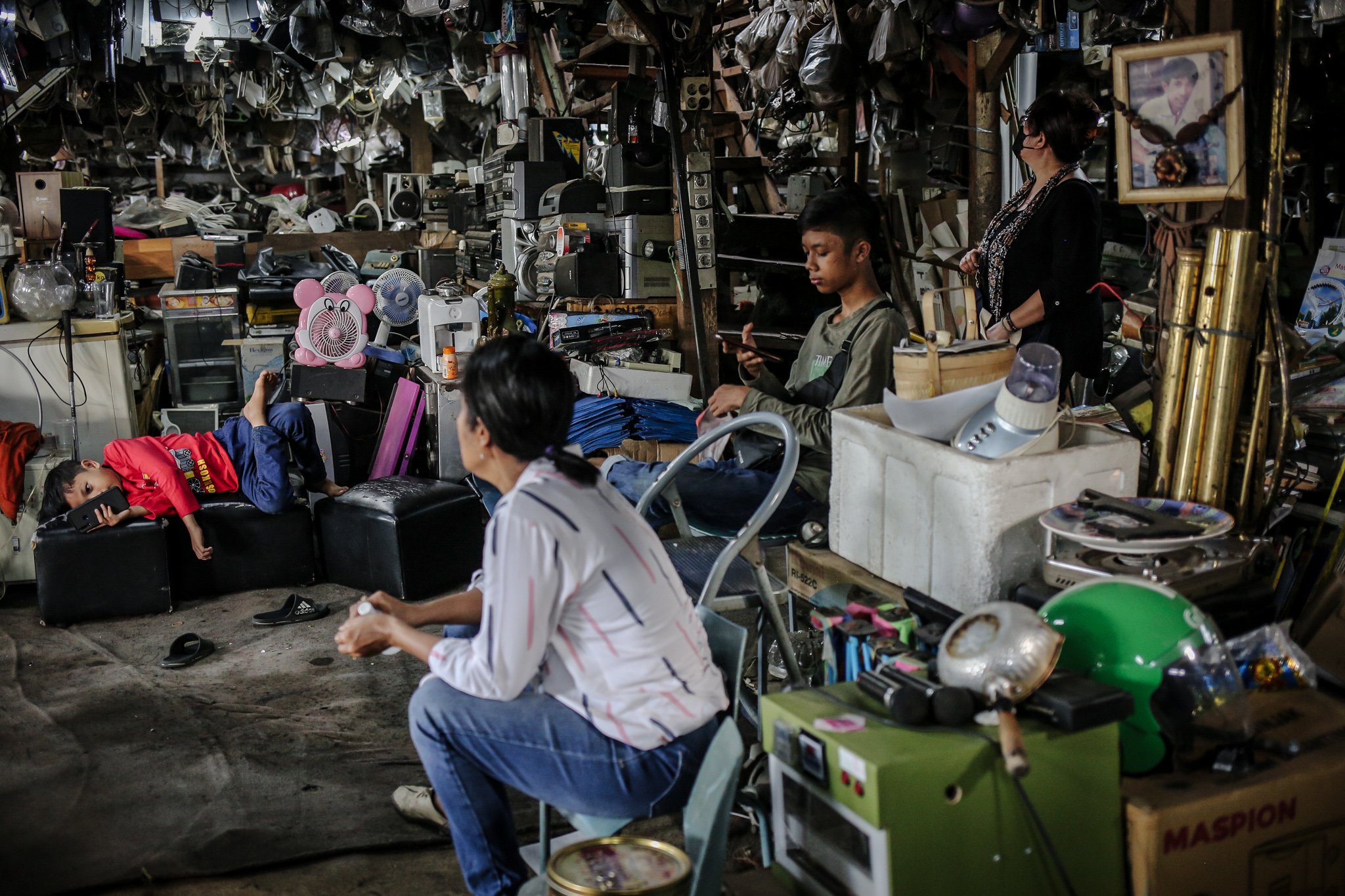 Pekerja menjaga barang-barang yang digantung di Mal Rongsok Beji, Depok, Jawa Barat, Jumat, (17/9/2021). Selama masa pandemi Covid-19, sekitar 82,9% pelaku UMKM alami penurunan omzet. pemilik Mal Rongsok itu juga mengaku demikian.