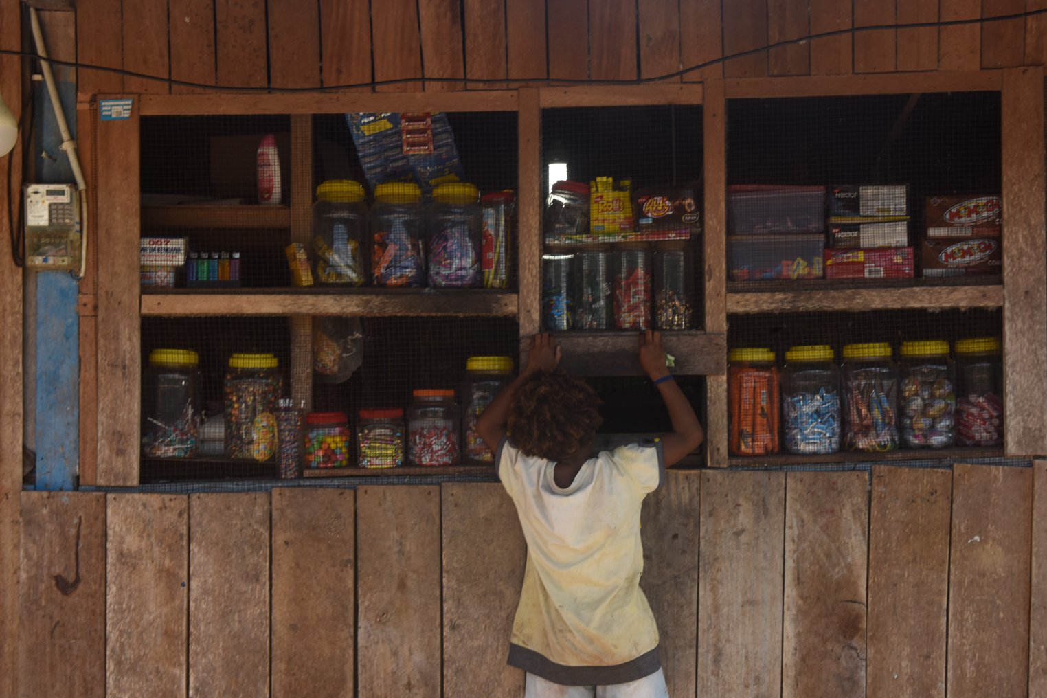 Seorang anak berbelanja di sebuah toko kelontong di Kampung Yoboi, Distrik Sentani, Jayapura