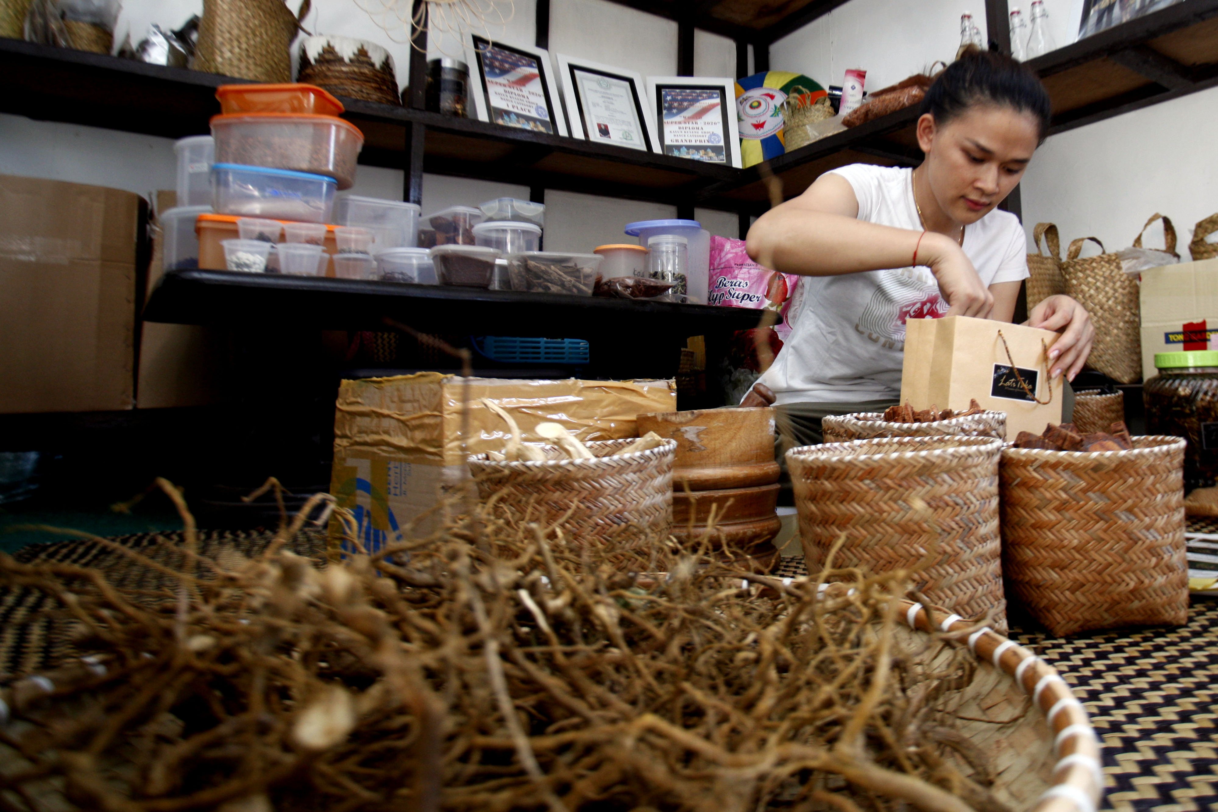 Pekerja menyelesaikan proses pengemasan produk racikan herbal berbahan dasar akar bajaka unutk dipasarkan di Balikpapan, Kamlimantan Timur.