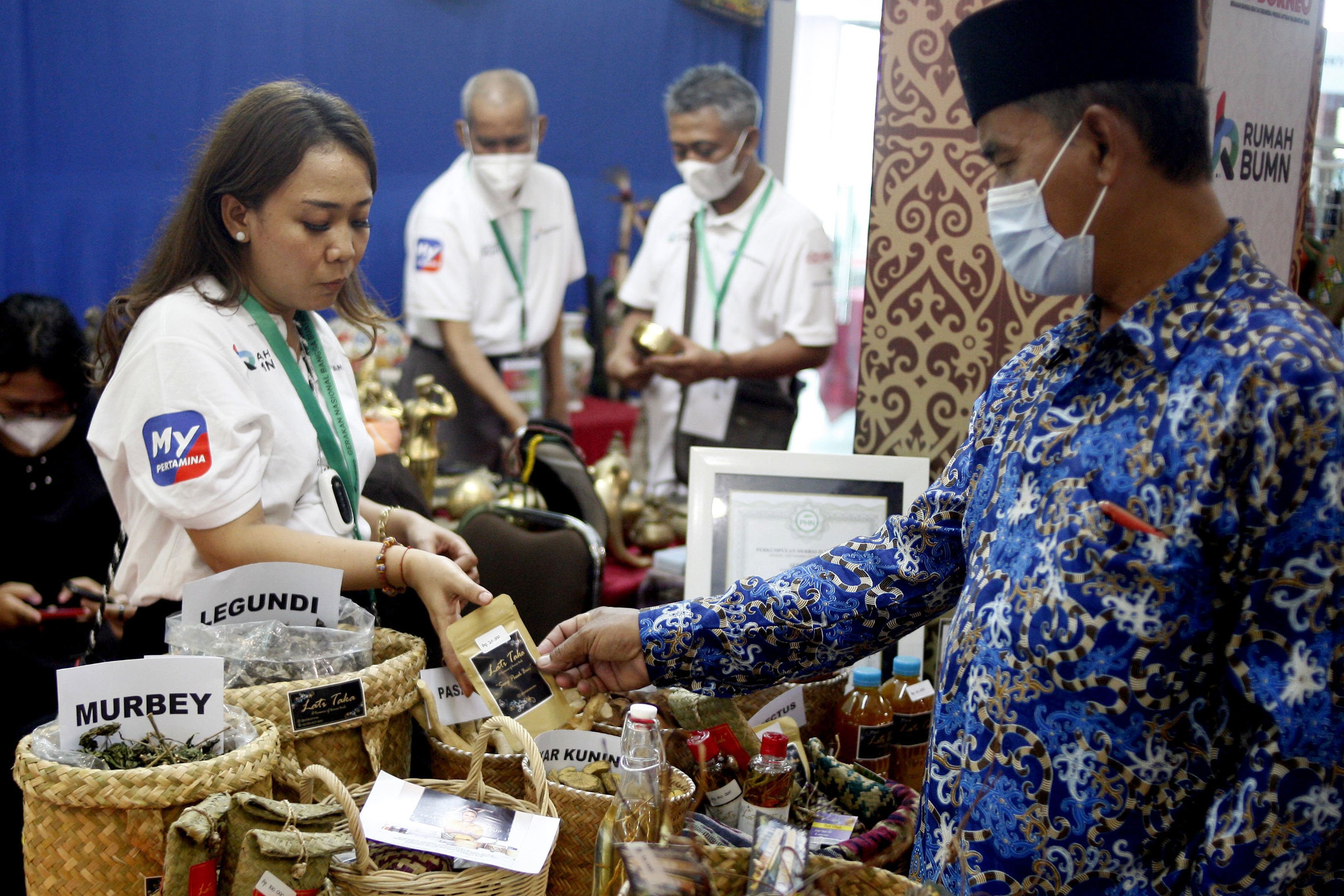 Pemilik UMKM Lati Taka Borneo, Mei Christy menawarkan pengunjung produk obat herbal tradisional saat Pameran Gerakan Nasinonal Bangga Buatan Indonesia dan Pertamina SMEXPO 2021 di Samarinda, Kalimantan Timur.