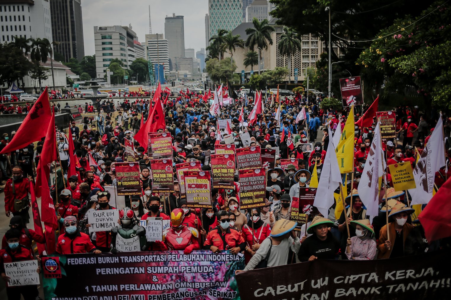 Masa aksi memegang panji-panji berisi tuntutan saat melakukan unjuk rasa di Wilayah Patung Kuda, Jakarta, Kamis (28/10/2021). Dalam aksinya demonstran yang tergabung dari mahasiswa dan buruh meyuarakan 13 tuntutan diantaranya Cabut Omnibus Law dan seluruh PP turunannya.