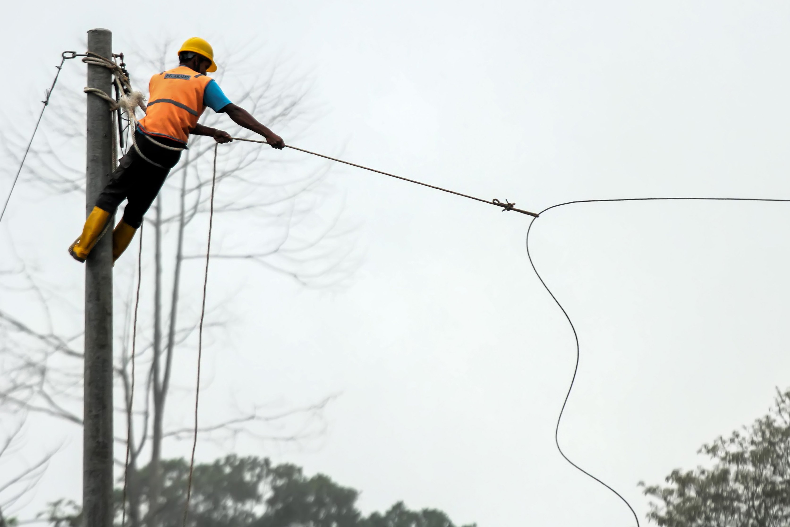 Pekerja menarik kabel listrik saat pengerjaan pemasangan jaringan listrik program listrik masuk wilayah desa tertinggal di Dusun Jabal Antara, Aceh Utara.