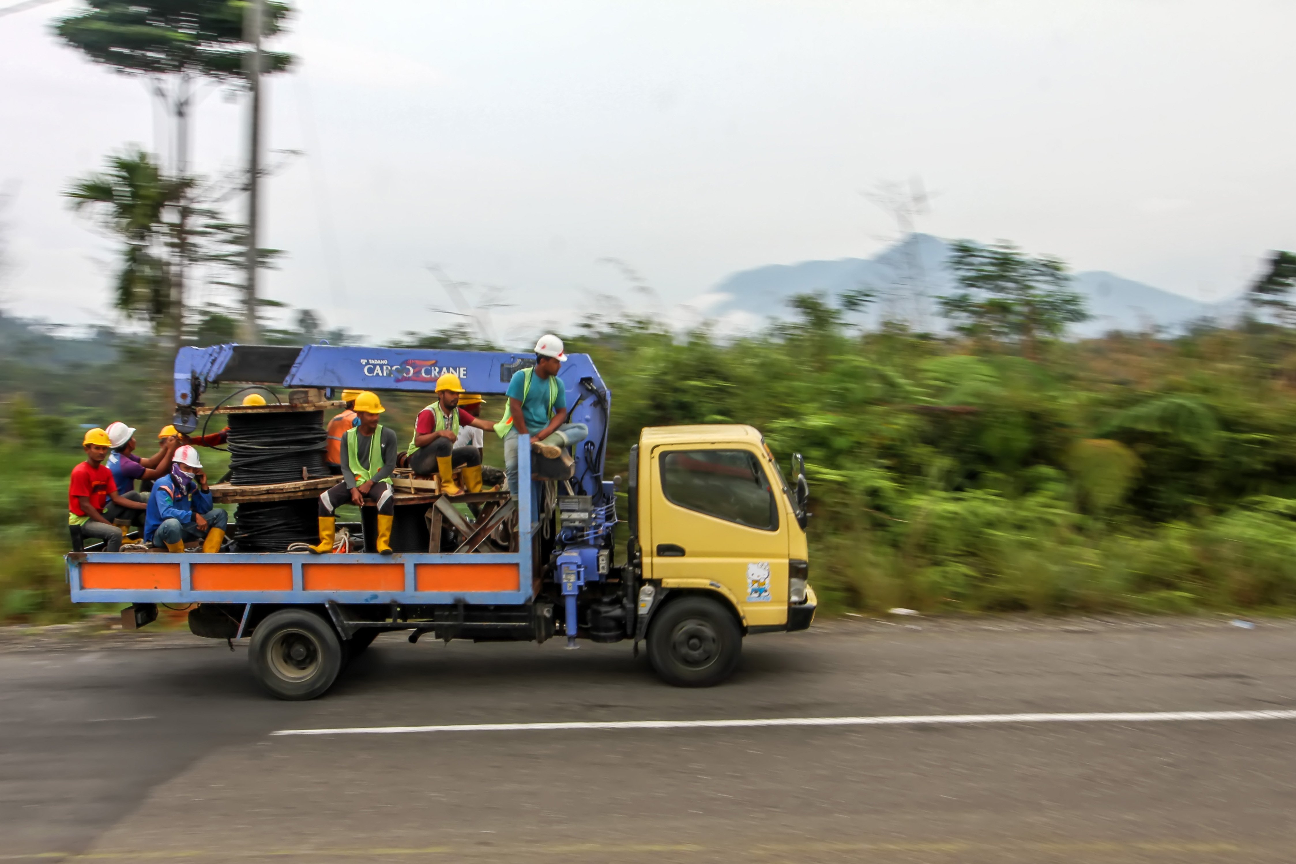Sebuah truk mengangkut peralatan kerja beserta pekerja melintasi wlayah perbukitan Gunung Sala saat pengerjaan pemasangan jaringan listrik program listrik masuk wilayah desa tertinggal di Dusun Jabal Antara, Aceh Utara.