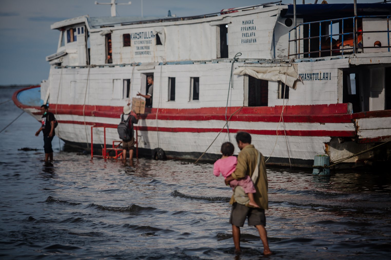 Sejumlah warga memuat barang ke kapal di wilayah Pelabuhan Perikanan Samudera Nizam Zachman yang terendam banjir rob di Muara Baru, Jakarta Utara, Selasa (9/11/2021). Laporan Fitch Solutions Country Risk & Industry Research memprediksi wilayah utara Jakarta dapat tenggelam secara menyeluruh pada tahun 2050 jika tidak ada intervensi lebih lanjut dari pemerintah.