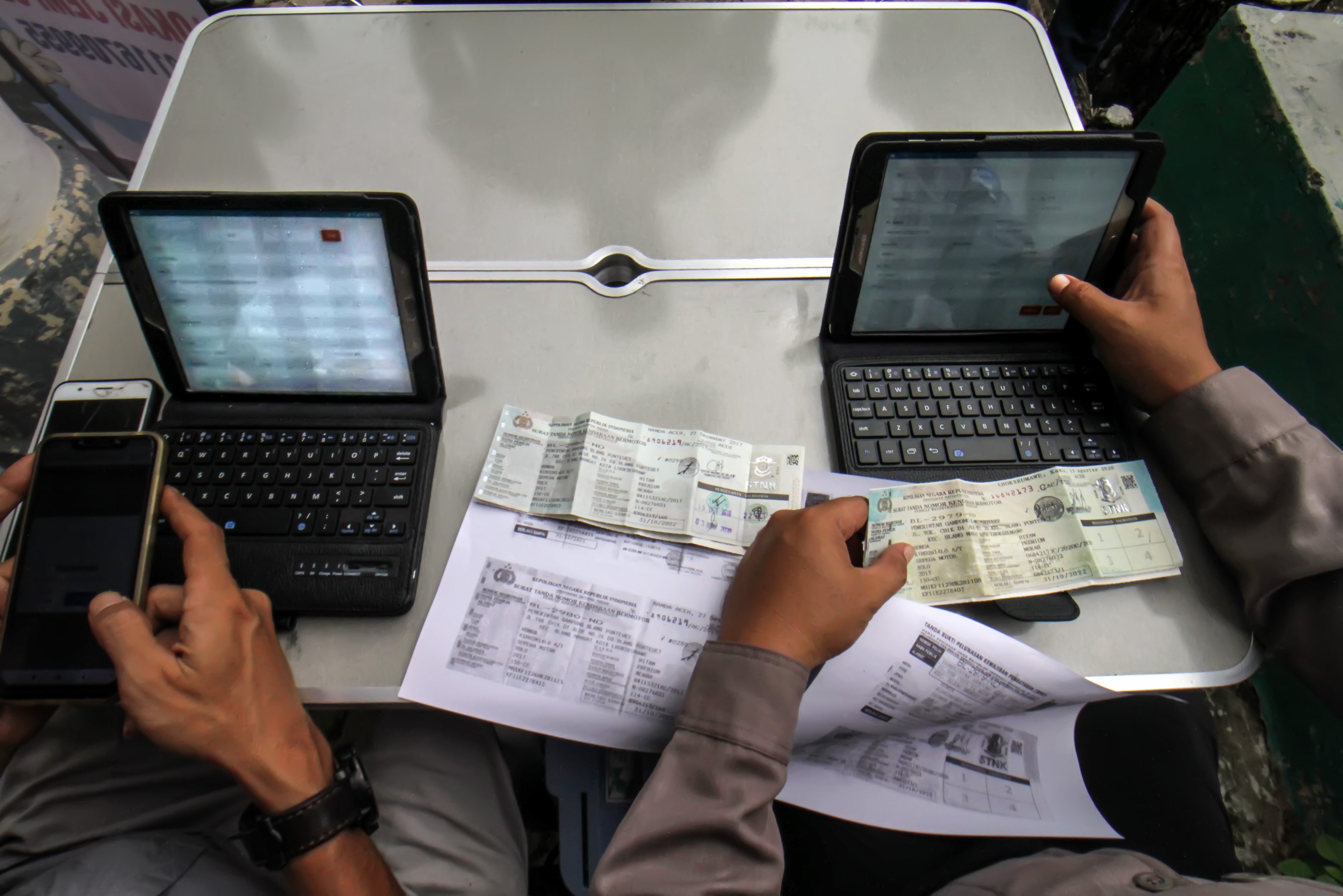 Petugas memeriksa dokumen STNK milik warga yang akan membayar pajak kendaraan secara daring melalui sepeda motor Sijempol di Kecamatan Blang Mangat, Lhoksumawe, Aceh.