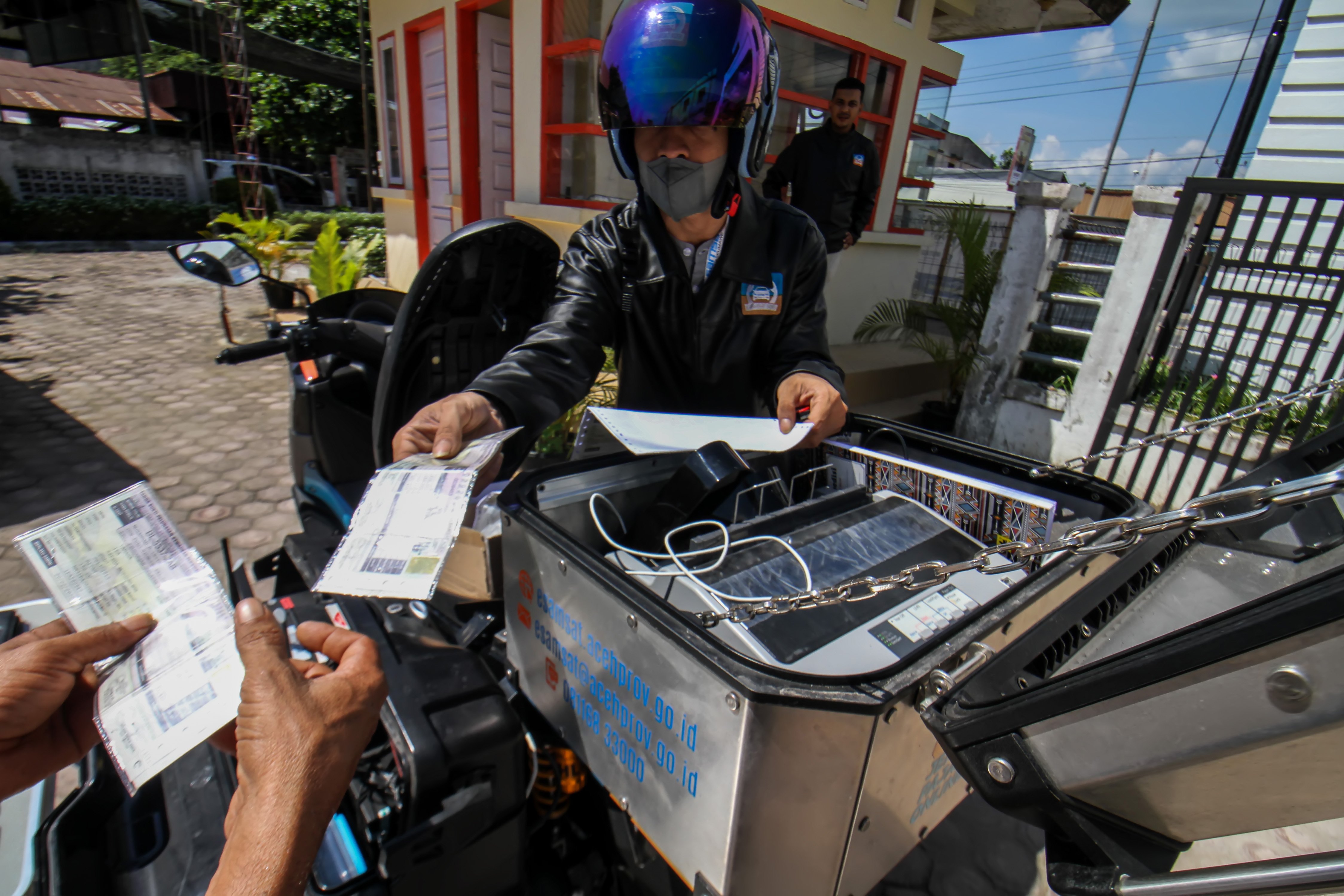 Petugas melayani warga melakukan pembayaran pajak kendaraan secara daring di Desa Panggoi, Lhoksumawe, Aceh.