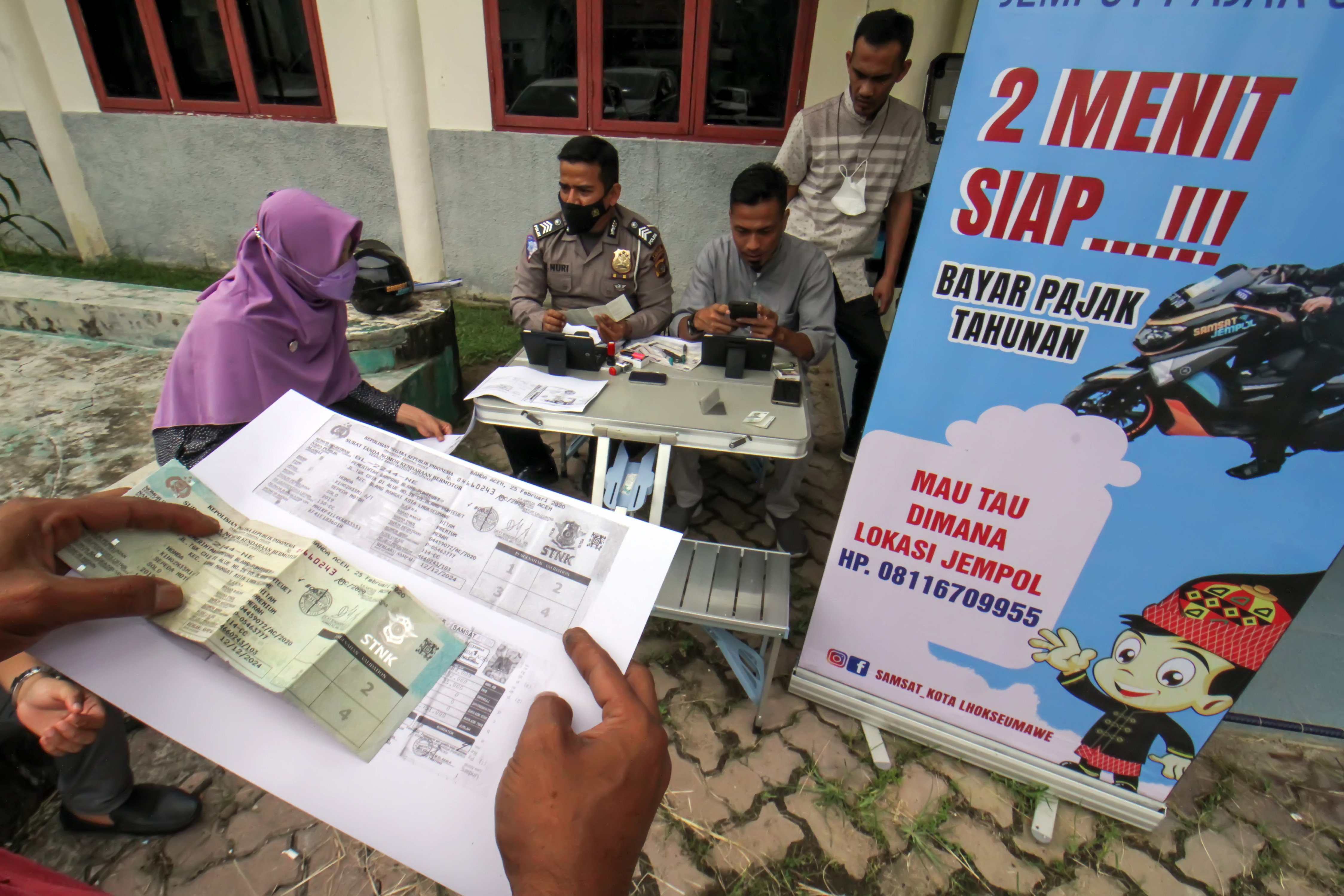 Sejumlah warga antre untuk melakukan pelunasan kewajiban pajak kendaraan secara daring melalui sepeda motor Sijempol di Kecamatan Blang Mangat, Lhoksumawe, Aceh.