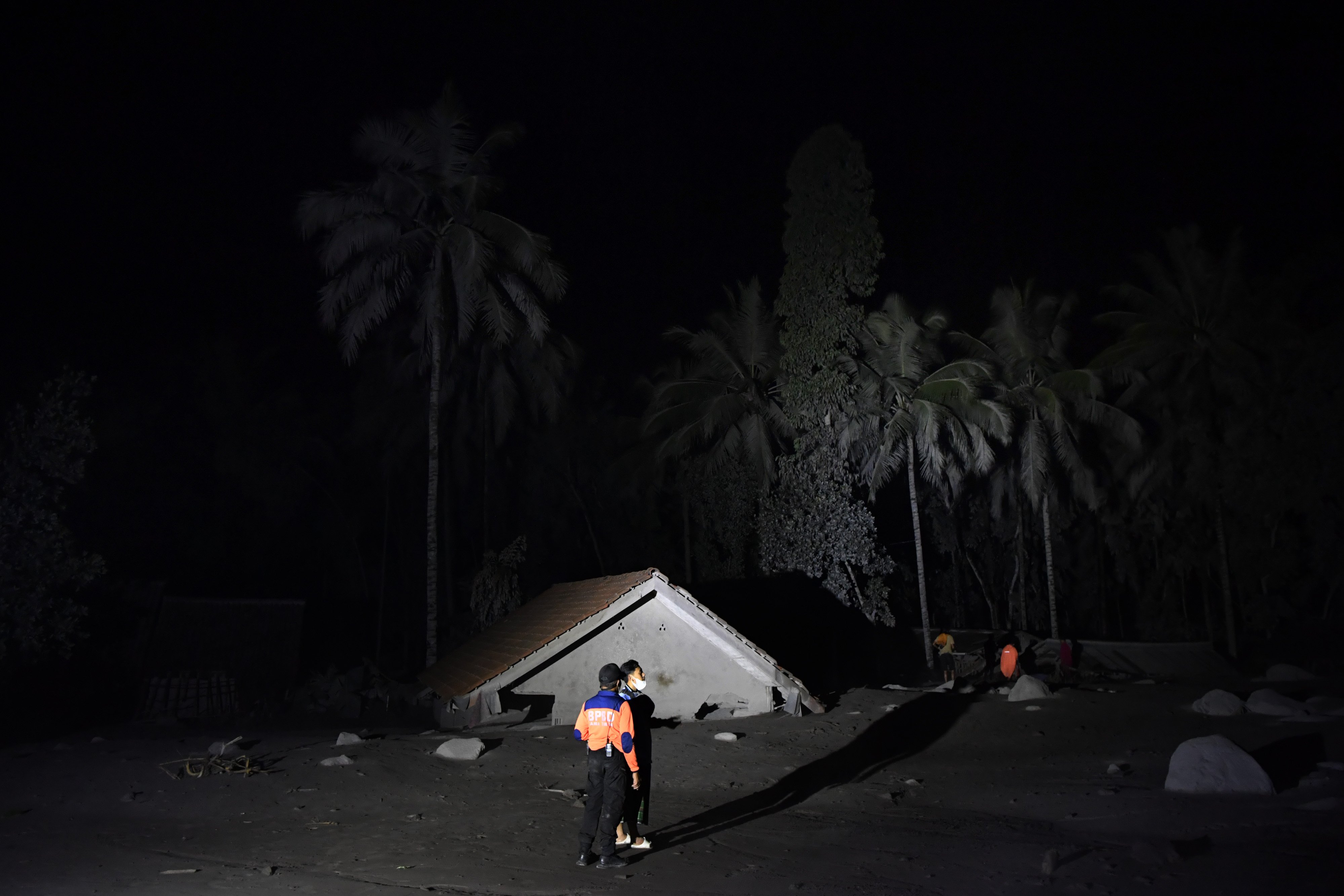 Warga mengamati kondisi rumah yang tertimbun abu vulkanik dari guguran awan panas Gunung Semeru di Desa Sumber Wuluh, Lumajang, Jawa Timur, Minggu (5/12/2021). Guguran awan panas Gunung Semeru mengakibatkan sedikitnya puluhan rumah warga rusak dan diperkirakan belasan warga dinyatakan hilang. ANTARA FOTO/Zabur Karuru/rwa.