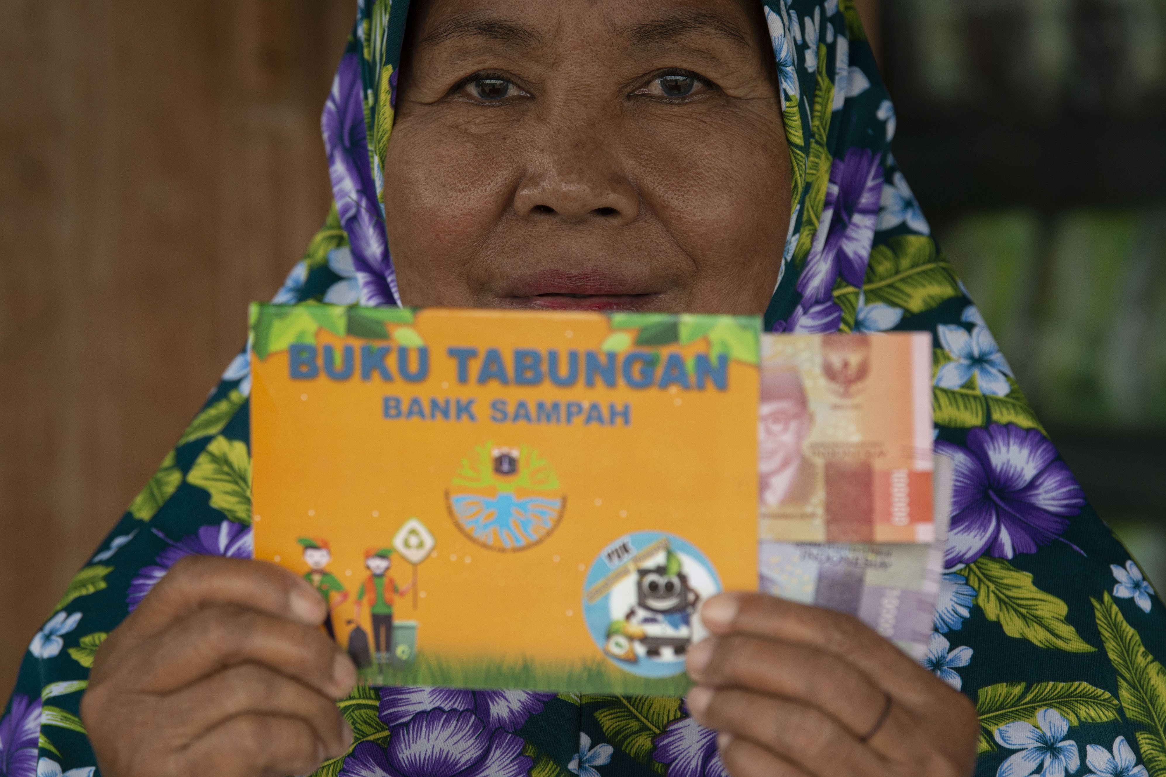 Sejumlah warga yang merupakan nasabah Bank Sampah Sabira Bersih Gembira menunjukkan hasil setoran sampah yang dikumpulkannya di Pulau Sabira, Kepulauan Seribu, Provinsi DKI Jakarta.