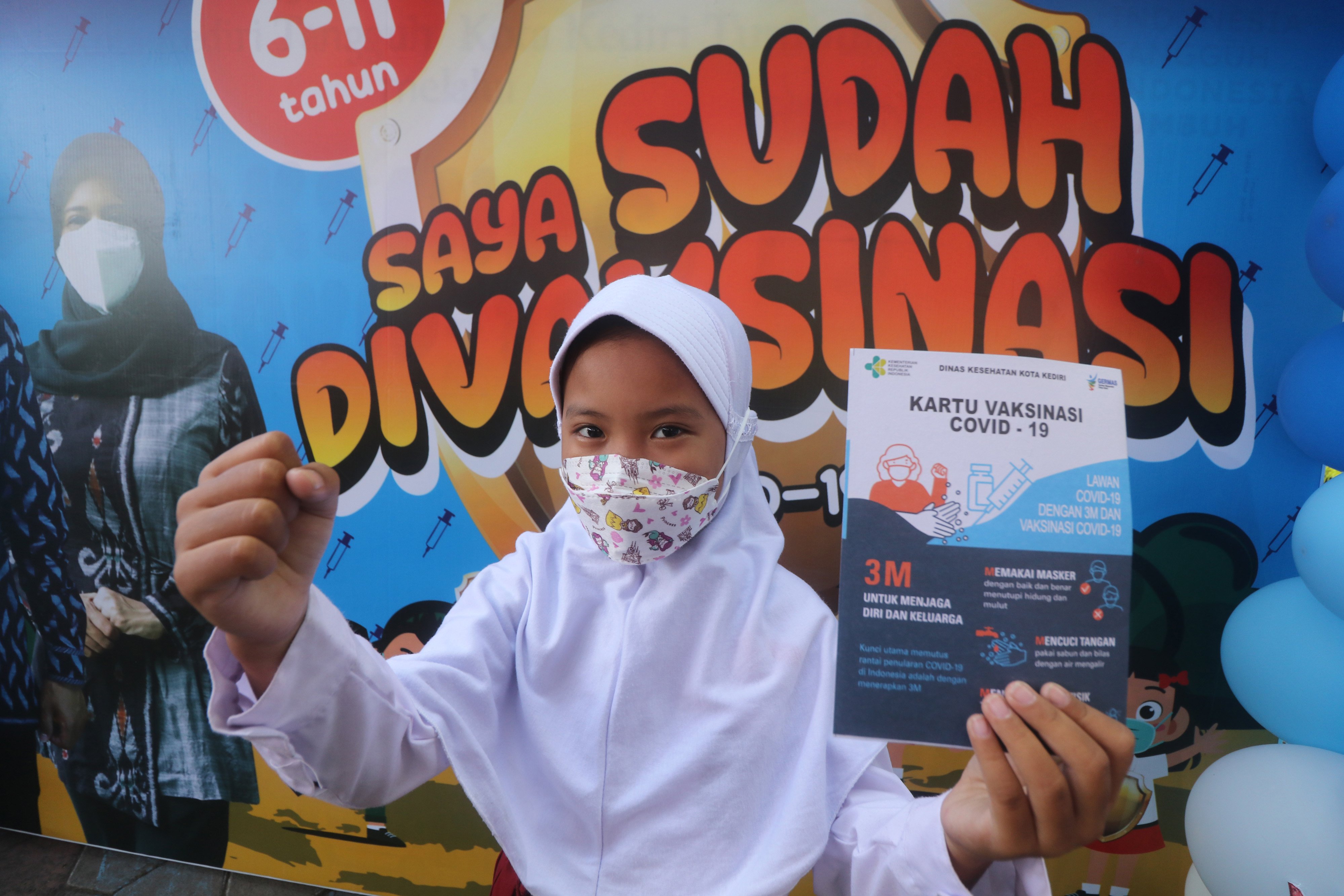 Seorang anak memperlihatkan kartu vaksinasi saat peluncuran vaksinasi COVID-19 untuk anak usia 6-11 tahun di SDN Banjaran Center, Kota Kediri, Jawa Timur, Kamis (16/12/2021). Vaksinasi COVID-19 bagi anak usia 6-11 tahun mulai dilaksanakan di 21 Kota/Kabupaten di Jawa Timur. ANTARA FOTO/Prasetia Fauzani/aww.