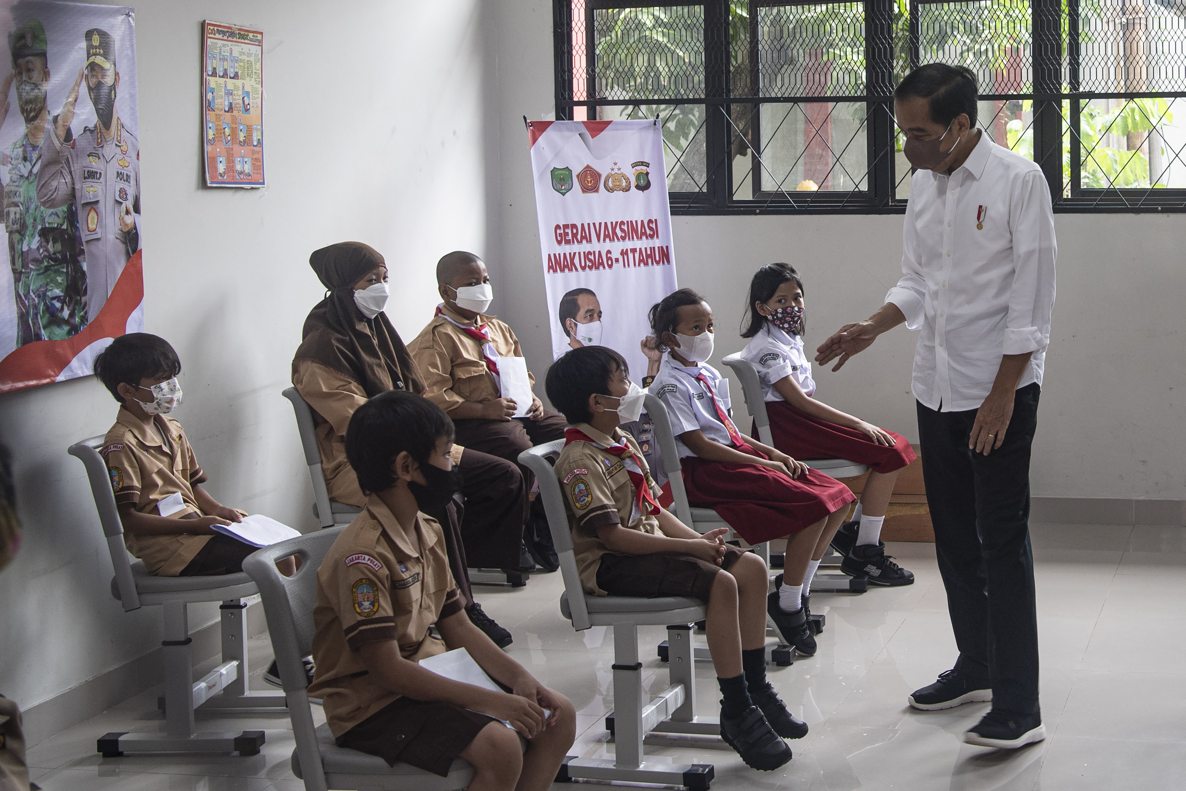 Presiden Joko Widodo (kanan) berdialog dengan sejumlah anak yang menunggu observasi setelah vaksinasi COVID-19 di Kompleks SDN Cideng, Gambir, Jakarta Pusat, Rabu (15/12/2021). Presiden meninjau langsung vaksinasi COVID-19 bagi anak-anak usia 6-11 tahun. ANTARA FOTO/Sigid Kurniawan/rwa.