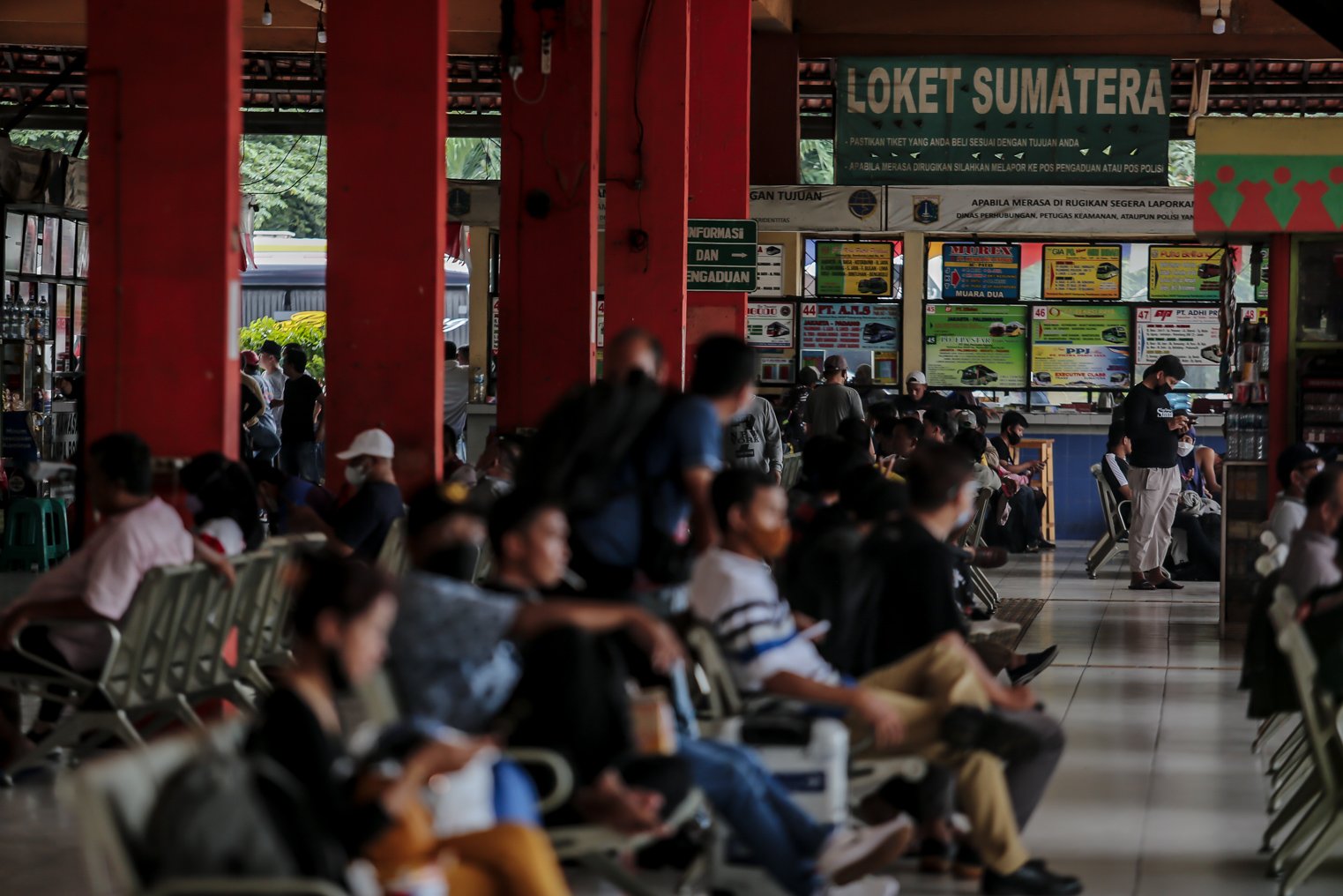 Sejumlah calon penumpang duduk mengantre sebelum keberangkatan di Terminal Kampung Rambutan, Jakarta, Selasa (21/12/2021). Kepala Terminal Kampung Rambutan Yulza Ramadhoni mengatakan, jumlah penumpang bus alami kenaikan hingga 10 persen pada menjelang Natal 2021 dan Tahun Baru 2022.