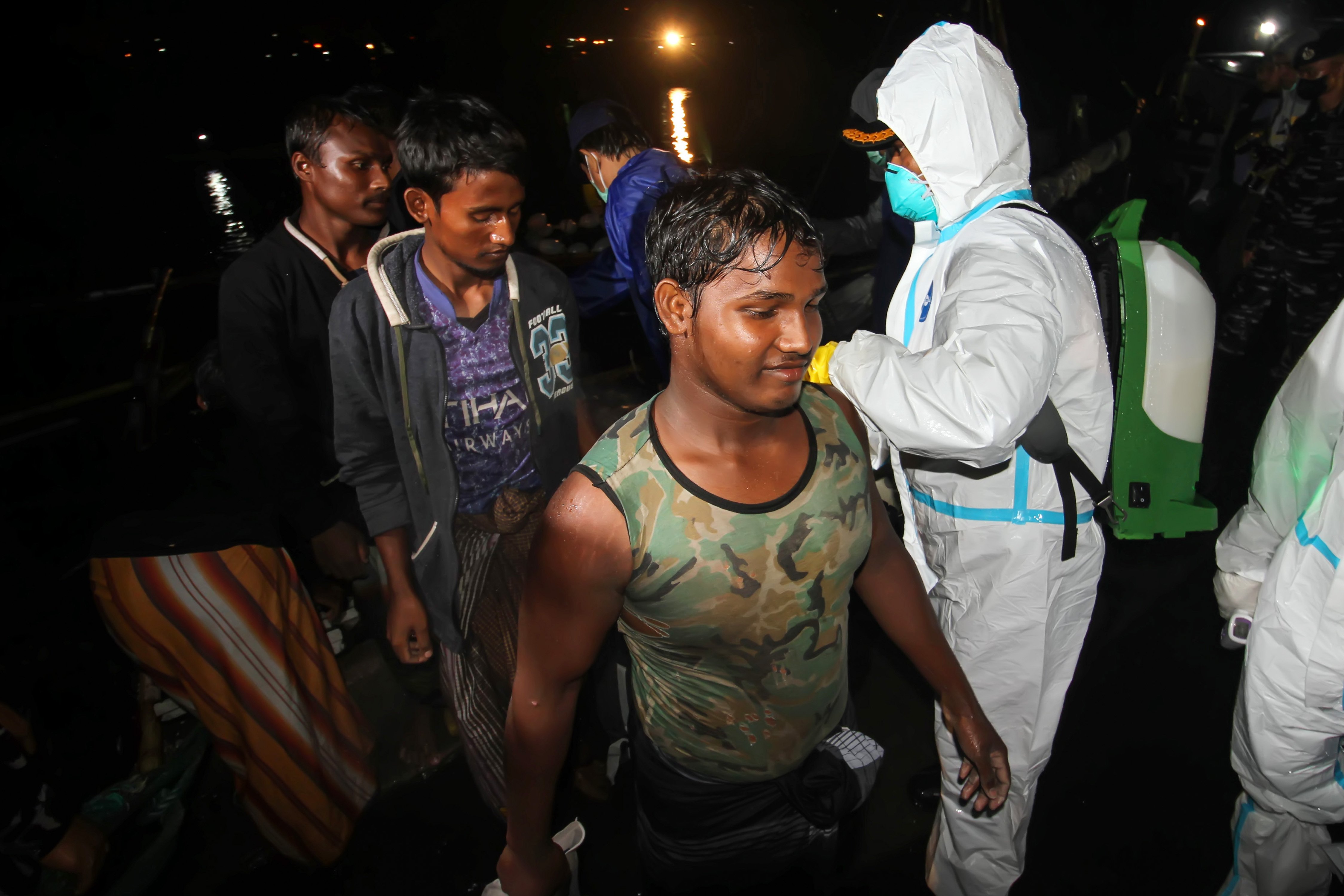Sejumlah pengungsi etnis Rohingya berjalan menuju bus saat proses evakuasi di Pelabuhan ASEAN, Krueng Geukuh, Aceh Utara, Aceh, Jumat (31/12/2021). Pemerintah Indonesia melalui Satgas Penanganan Pengungsi Luar Negeri (PPLN) mempertimbangkan keadaan darurat dan sisi kemanusiaan sehingga memutuskan untuk menyelamatkan 120 orang etnis Rohingya terdiri dari tujuh laki-laki, 62 perempuan dan 51 anak-anak yang terdampar di perairan laut Aceh pada Sabtu (25/12/2021). ANTARA FOTO/Rahmad/nym.