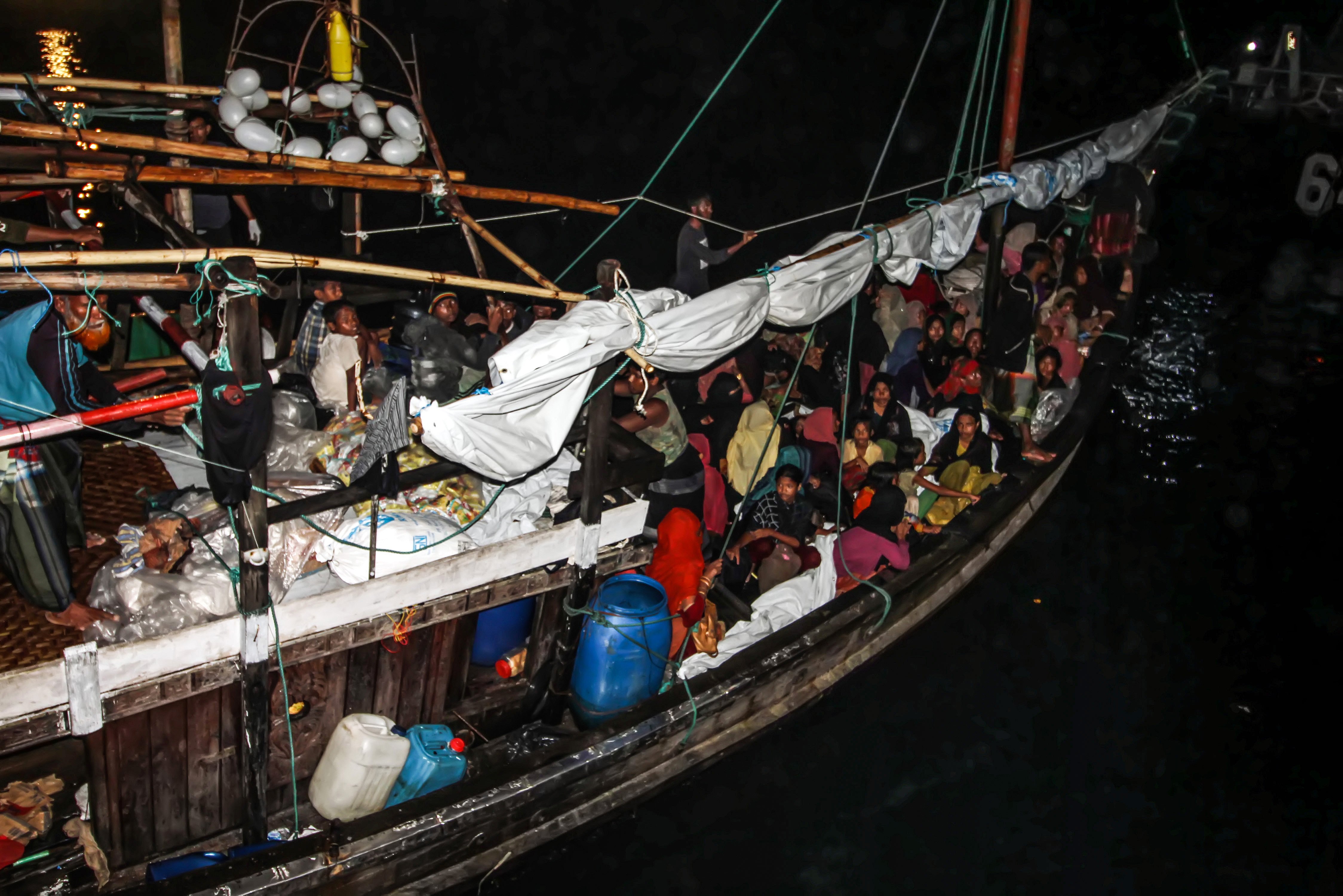 Pengungsi etnis Rohingya menunggu di atas kapal saat proses evakuasi oleh TNI AL ke Pelabuhan ASEAN, Krueng Geukuh, Aceh Utara, Aceh, Jumat (31/12/2021). Pemerintah Indonesia melalui Satgas Penanganan Pengungsi Luar Negeri (PPLN) mempertimbangkan keadaan darurat dan sisi kemanusiaan sehingga memutuskan untuk menyelamatkan 120 orang etnis Rohingya terdiri dari tujuh laki-laki, 62 perempuan dan 51 anak-anak yang terdampar di perairan laut Aceh pada Sabtu (25/12/2021). ANTARA FOTO/Rahmad/nym.