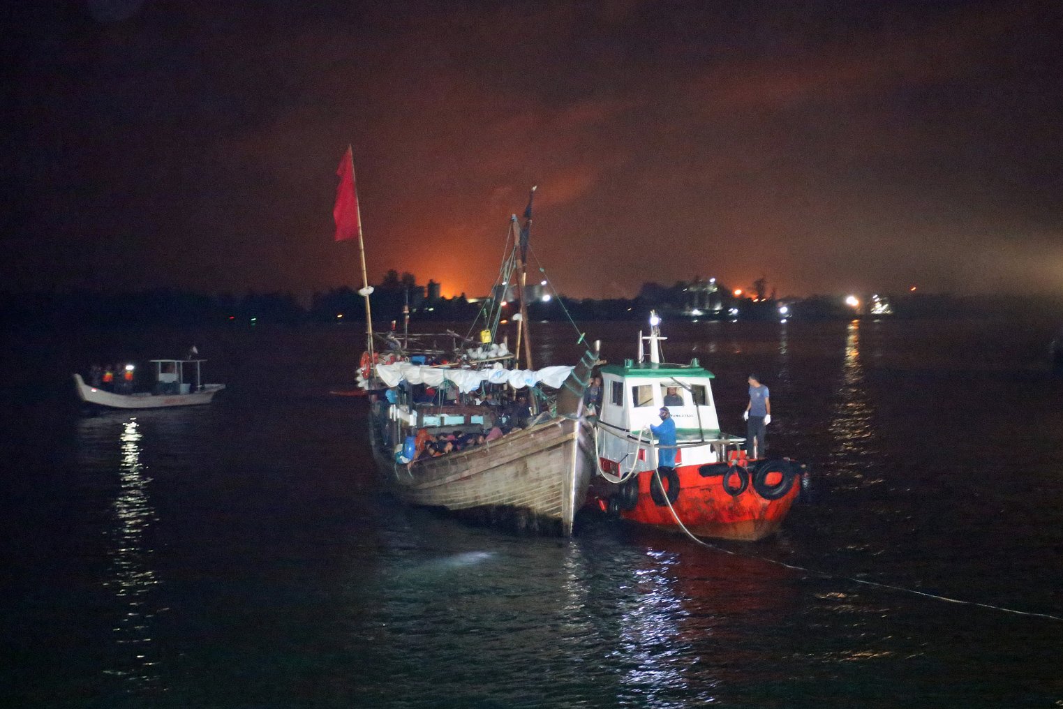 Petugas menggiring kapal pegungsi etnis Rohingya saat proses evakuasi di Pelabuhan ASEAN, Krueng Geukuh, Aceh Utara, Aceh, Jumat (31/12/2021). Pemerintah Indonesia melalui Satgas Penanganan Pengungsi Luar Negeri (PPLN) mempertimbangkan keadaan darurat dan sisi kemanusiaan sehingga memutuskan untuk menyelamatkan 120 orang etnis Rohingya terdiri dari tujuh laki-laki, 62 perempuan dan 51 anak-anak yang terdampar di perairan laut Aceh pada Sabtu (25/12/2021). ANTARA FOTO/Syifa Yulinnas/nym.