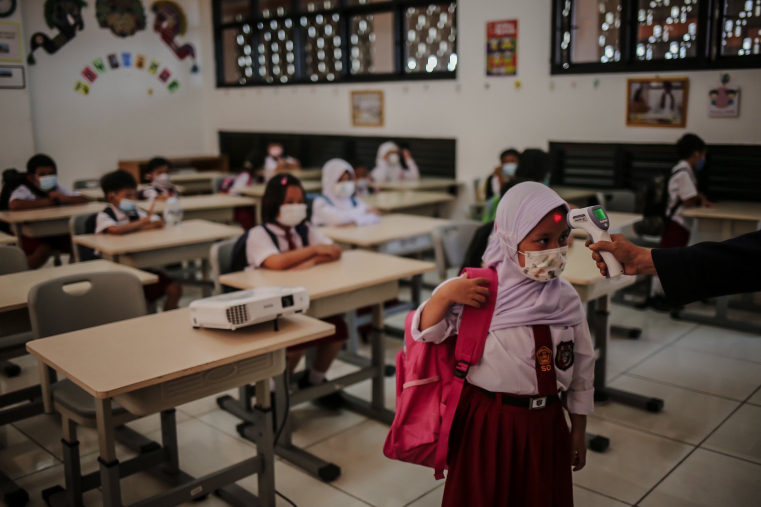 Sejumlah siswi di cek suhu tubuhnya usai mengikuti Pembelajaran Tatap Muka (PTM) di Sekolah Dasar Negeri (SDN) 01 Pondok Labu, Jakarta Selatan, Selasa (4/1/2022). Pemerintah Provinsi (Pemprov) DKI Jakarta resmi menerapkan Pembelajaran Tatap Muka (PTM) dengan kapasitas 100 persen di seluruh sekolah mulai hari Senin (3/1). Relaksasi kebijakan ini sesuai dengan kondisi PPKM Level 1 yang diterapkan di Jakarta.