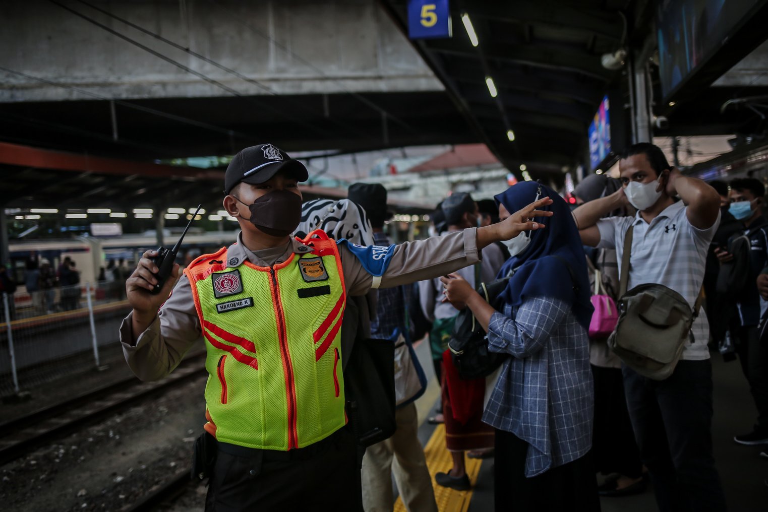 Petugas menertibkan calon penumpang saat menunggu commuter line di peron Stasiun Tanah Abang, Jakarta Pusat, Rabu (5/1/2022). Memasuki masa PPKM Level 2, Stasiun Tanah Abang kembali dipadati penumpang saat jam pulang kerja.