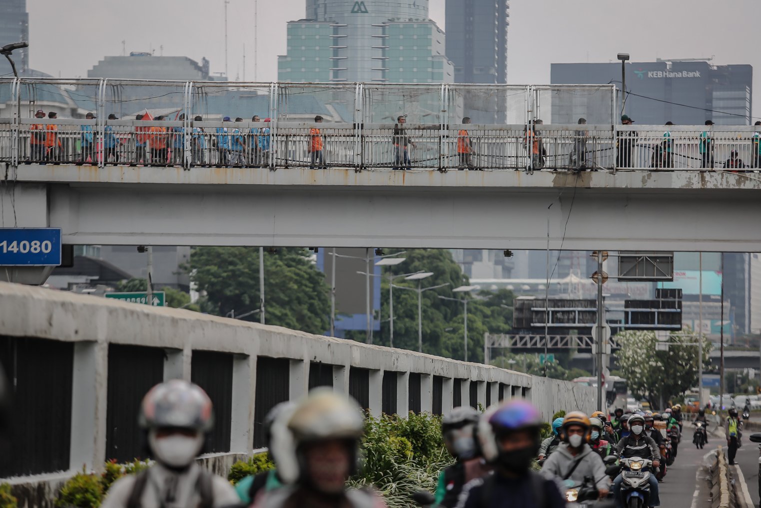 Sejumlah buruh berjalan di Jembatan penyebranagn hendak bergabung melakukan aksi unjuk rasa di depan Gedung DPR RI, Jakarta, Jumat (14/1/2022). Dalam aksinya ribuan buruh se-Jabodetabek ini memiliki empat tnututan salah satunya yakni mendorong pemerintah untuk mencabut UU Omnibus Law Cipta Kerja.