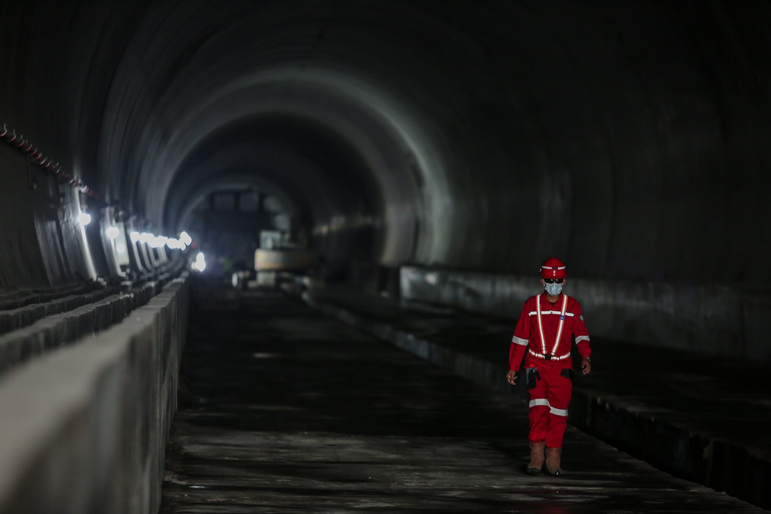 Pekerja berjalan di area proyek Tunnel 6 Kereta Cepat Jakarta Bandung sepanjang panjang 4.478 meter atau 4,4 kilometer yang berlokasi di kawasan Cikalong Wetan, Depok, Purwaarta, Kamis (27/1/2022). Tunnel ini menjadi salah satu tunnel terpanjang yang ditargetkan dalam waktu dekat akan tembus karena progres konstruksi sudah mencapai 97,01 persen.