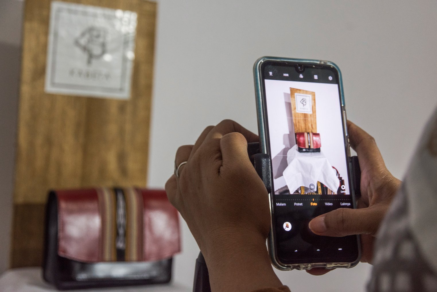 Penenun Kelompok Ralsasam memotret produk dompet dan tas tenun ikat Tanimbar menggunakan alat tenun tradisional untuk dipasarkan secara digital di studio Kabeta Craft, Ambon, Maluku. ANTARA FOTO/ FB Anggoro/AW.