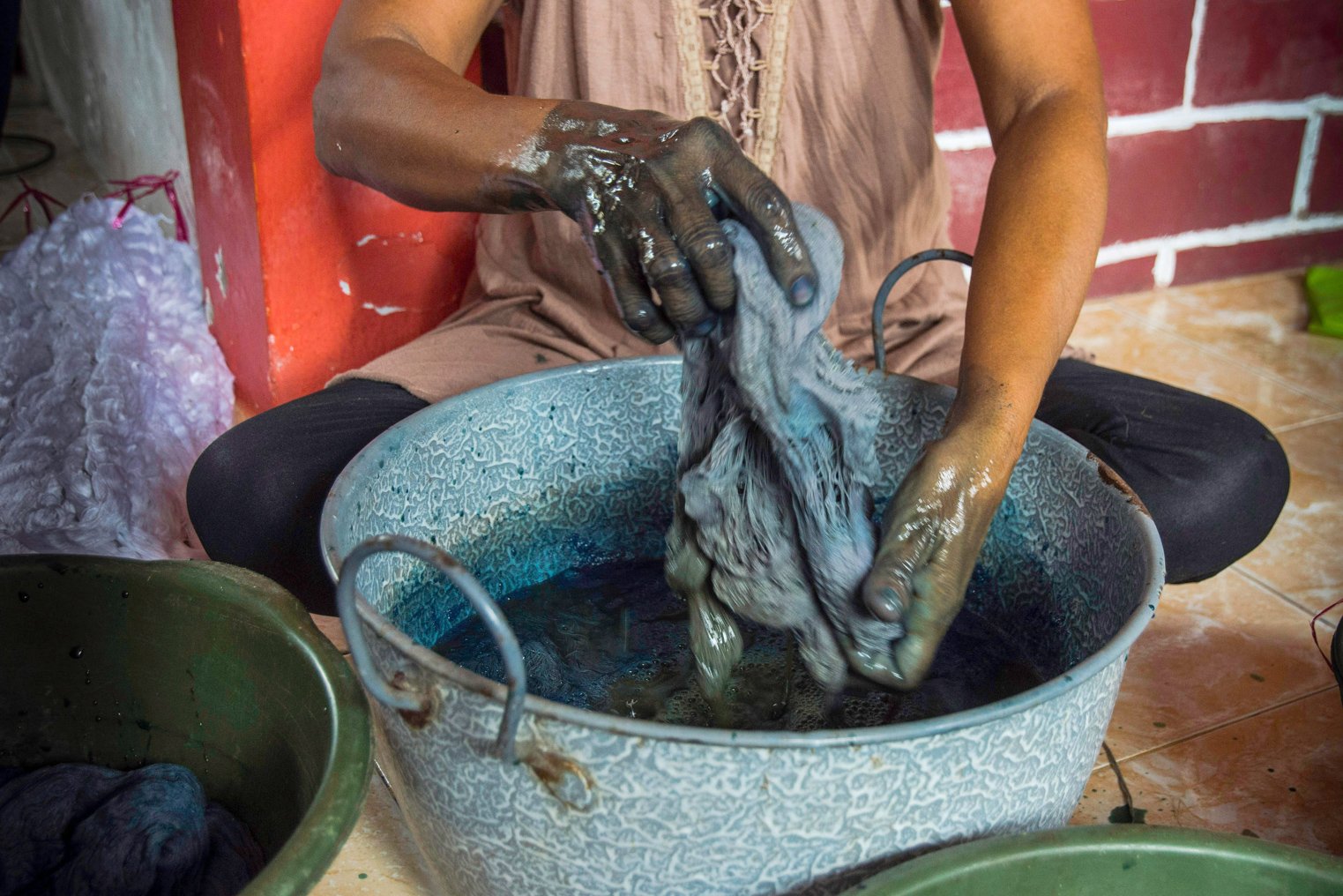 Anggota kelompok Ralsasam merendam kain ke dalam cairan pewarna berbahan dasar daun taro yang digunakan sebagai pewarna alami kain tenun ikat Tanimbar, Ambon, Maluku. ANTARA FOTO/ FB Anggoro/AW.