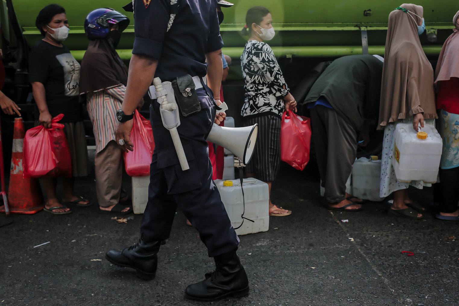 Petugas keamanan menertibkan warga yang berbaris antre membeli minyak goreng murah di Pasar Kramat Jati, Jakarta, Kamis (3/2/2022). Berdasarkan kebijakan pemerintah Harga Eceran Tertinggi (HET) untuk minyak goreng curah Rp 11.500 per liter, minyak goreng kemasan sederhana Rp 13.500 per liter dan minyak goreng premium Rp 14.500 per liter.