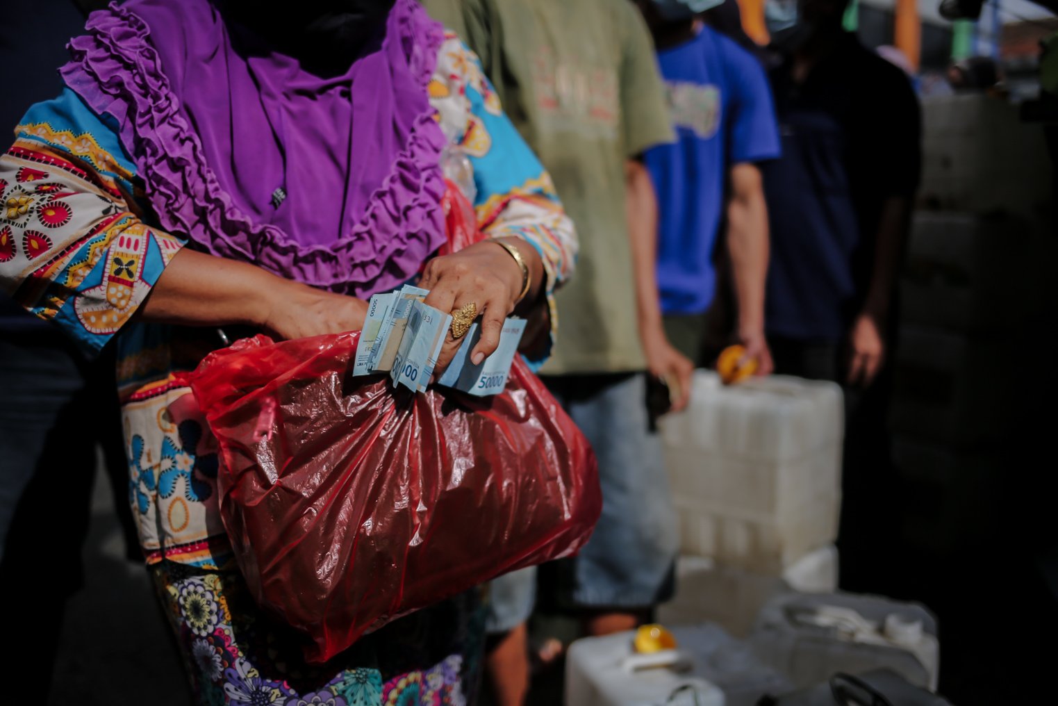 Warga menyiapkan uang saat berbaris mengantre membeli minyak goreng murah di Pasar Kramat Jati, Jakarta, Kamis (3/2/2022). Berdasarkan kebijakan pemerintah Harga Eceran Tertinggi (HET) untuk minyak goreng curah Rp 11.500 per liter, minyak goreng kemasan sederhana Rp 13.500 per liter dan minyak goreng premium Rp 14.500 per liter.