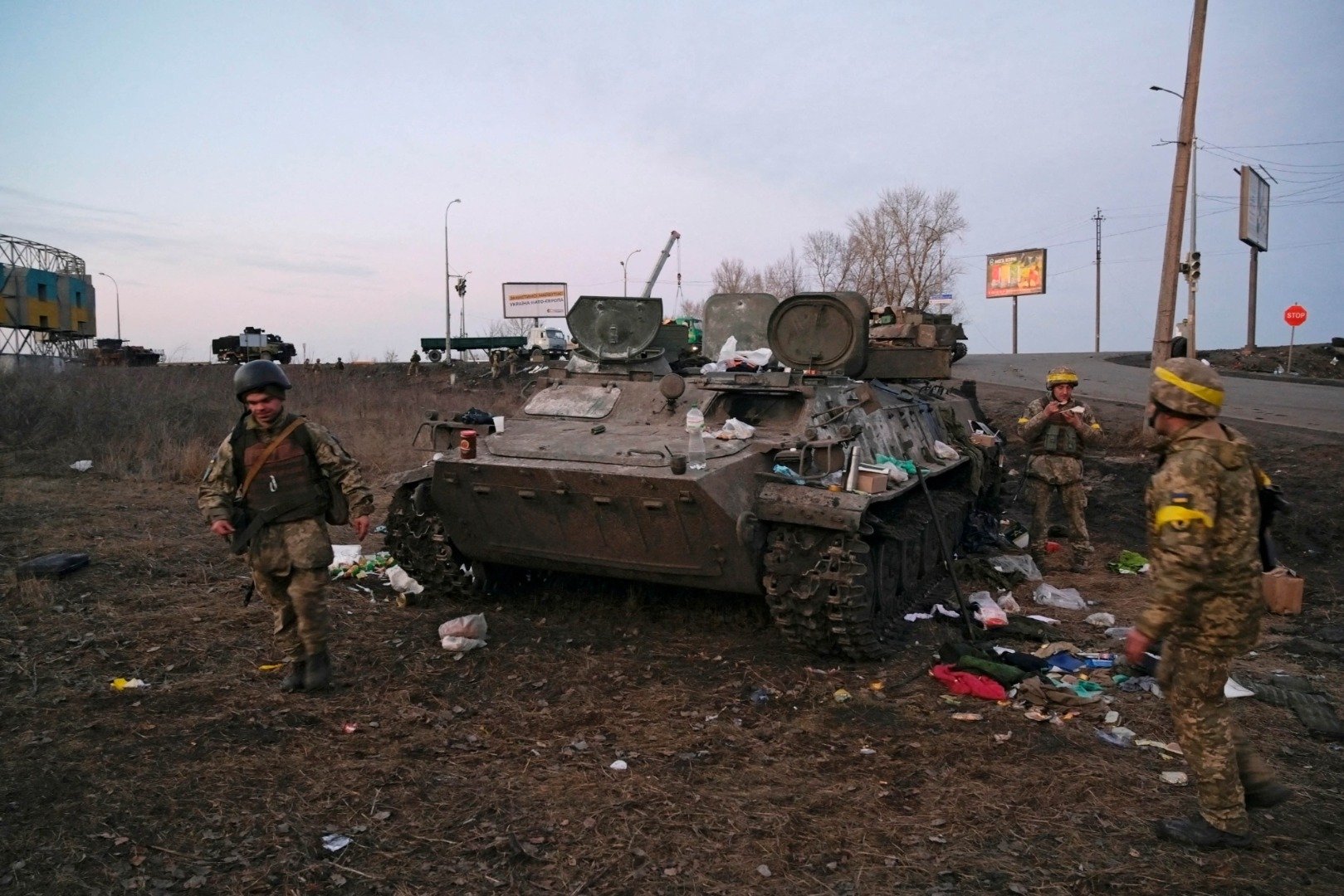 Tentara Ukraina terlihat di samping kendaraan lapis baja yang hancur, yang menurut mereka milik tentara Rusia, di luar Kharkiv, Ukraina, Kamis (24/2/2022). ANTARA FOTO/REUTERS/Maksim Levin/hp/cfo