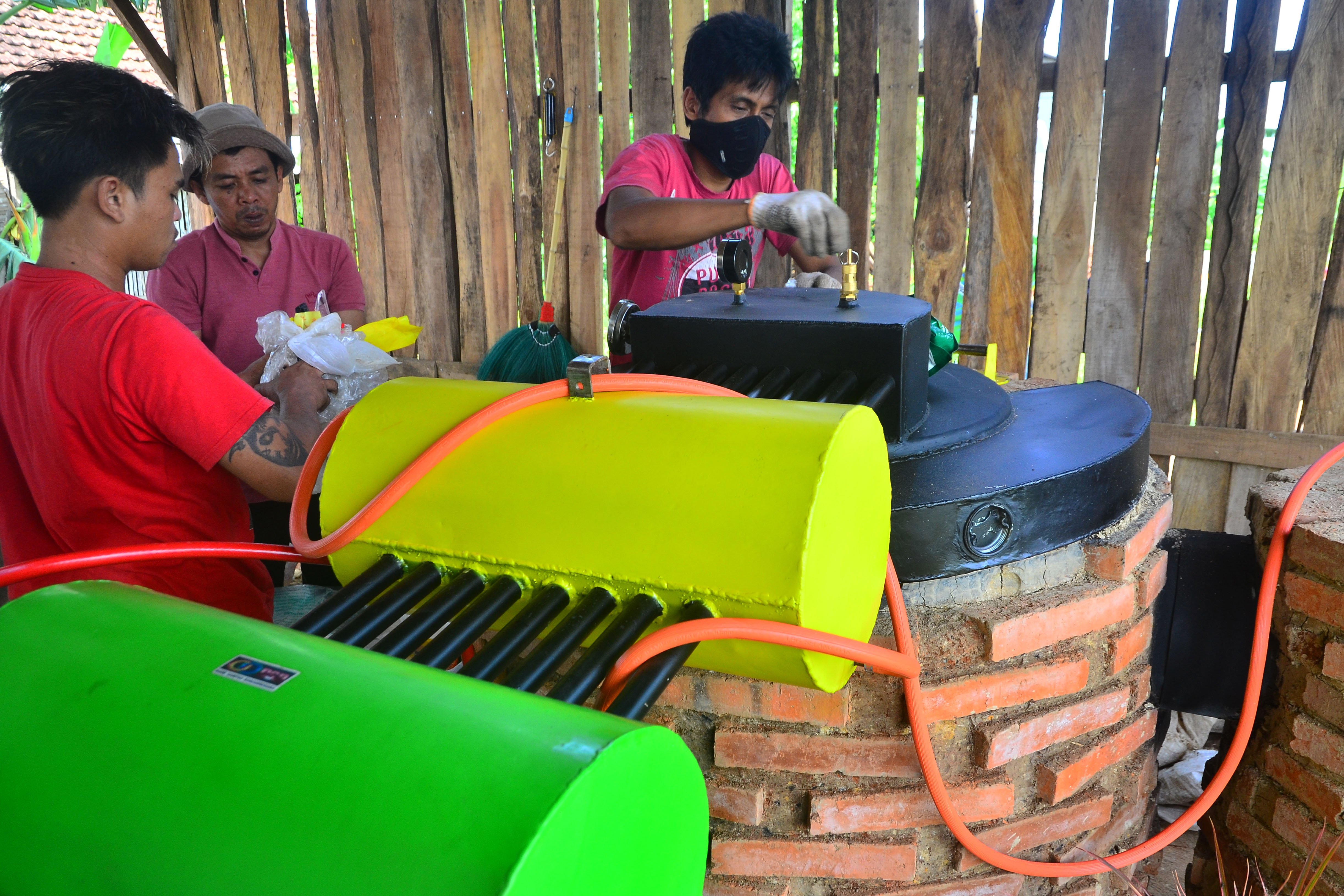 Warga memasukan sampah plastik ke dalam mesin prirolisis di tempat pengolahan sampah di Desa Sidorekso, Kudus, Jawa Tengah.