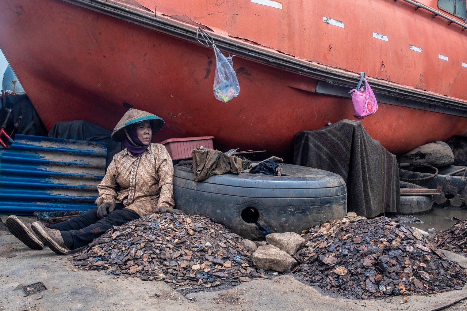Surati beristirahat di antara tumpukan besi karat di kawasan Belah Kapal, Cilincing, Jakarta Utara.