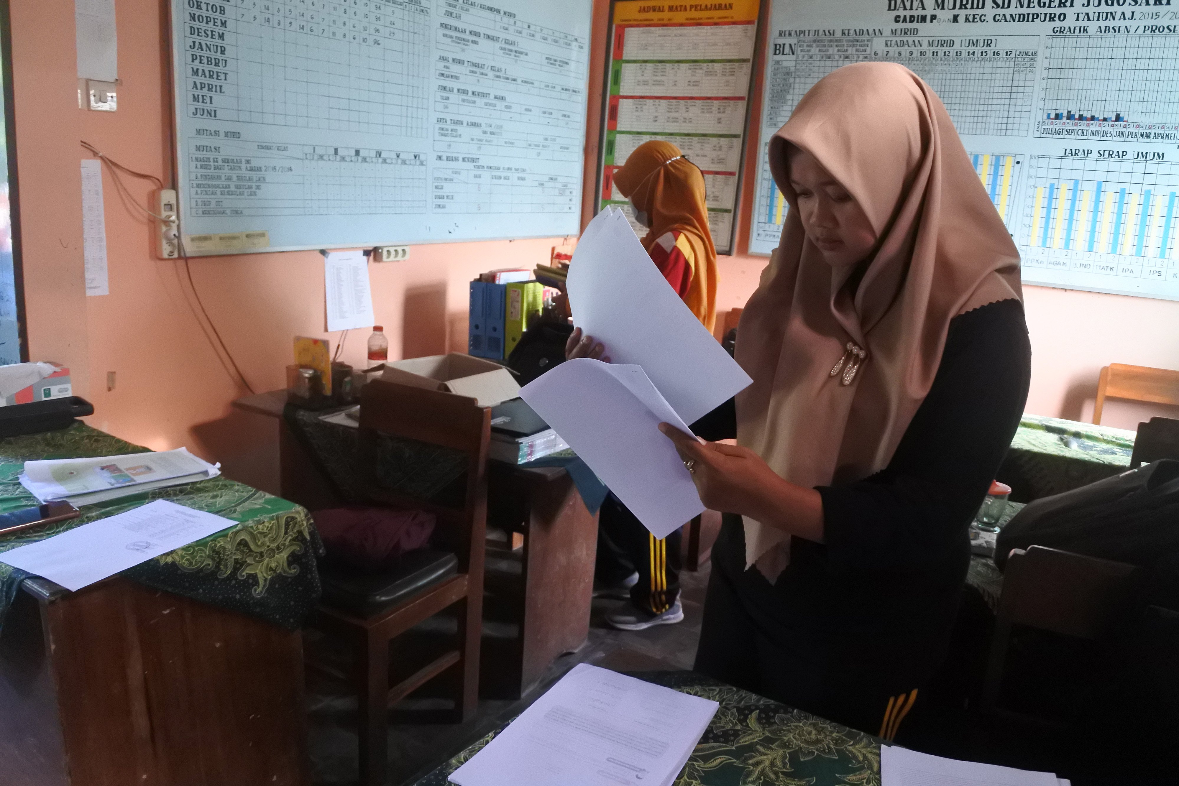 Guru SDN Jugosari 03 Eri Eliyawati menyiapkan materi pelajaran di Candipuro, Lumajang, Jawa Timur.