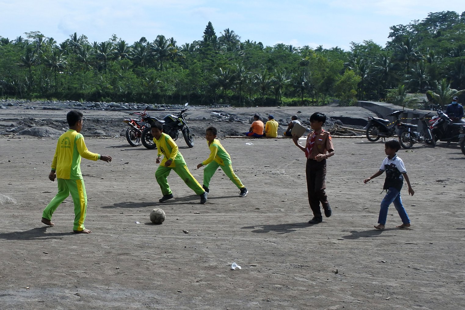 Sejumlah murid SDN Jugosari 03 bermain bola di pinggir Sungai Regoyo di Desa Jugosari, Candipuro, Lumajang, Jawa Timur.