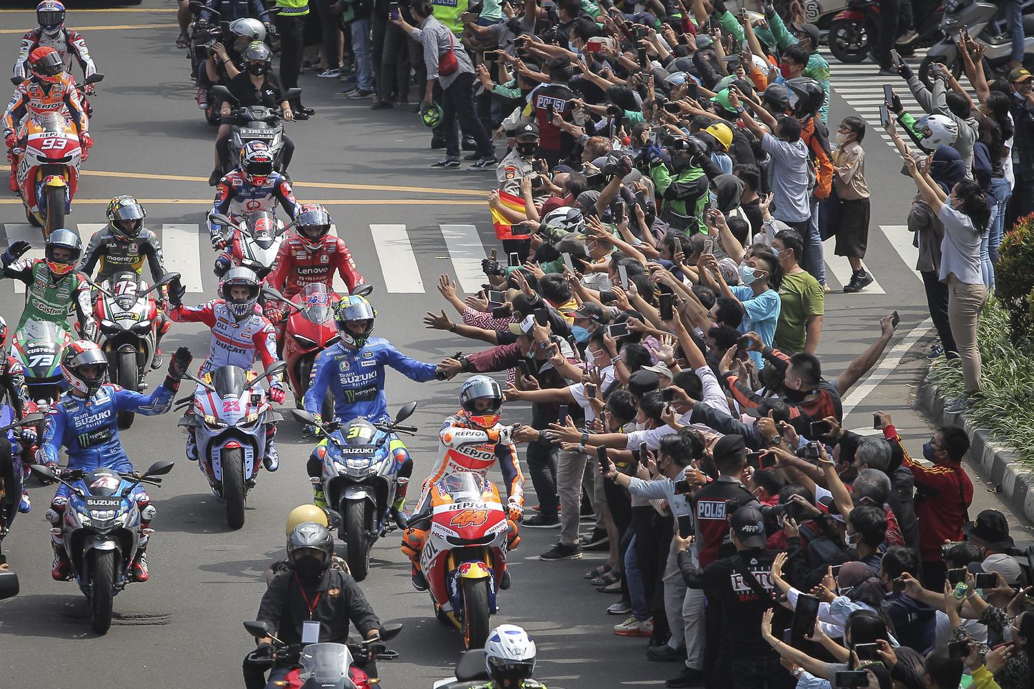 Sejumlah pembalap MotoGP menyapa warga saat mengikuti parade di kawasan Jalan M.H.Thamrin, Jakarta, Rabu (16/3/2022). Parade digelar untuk memeriahkan seri kedua MotoGP yang akan diselenggarakan di Sirkuit Mandalika pada 18-20 Maret 2022.