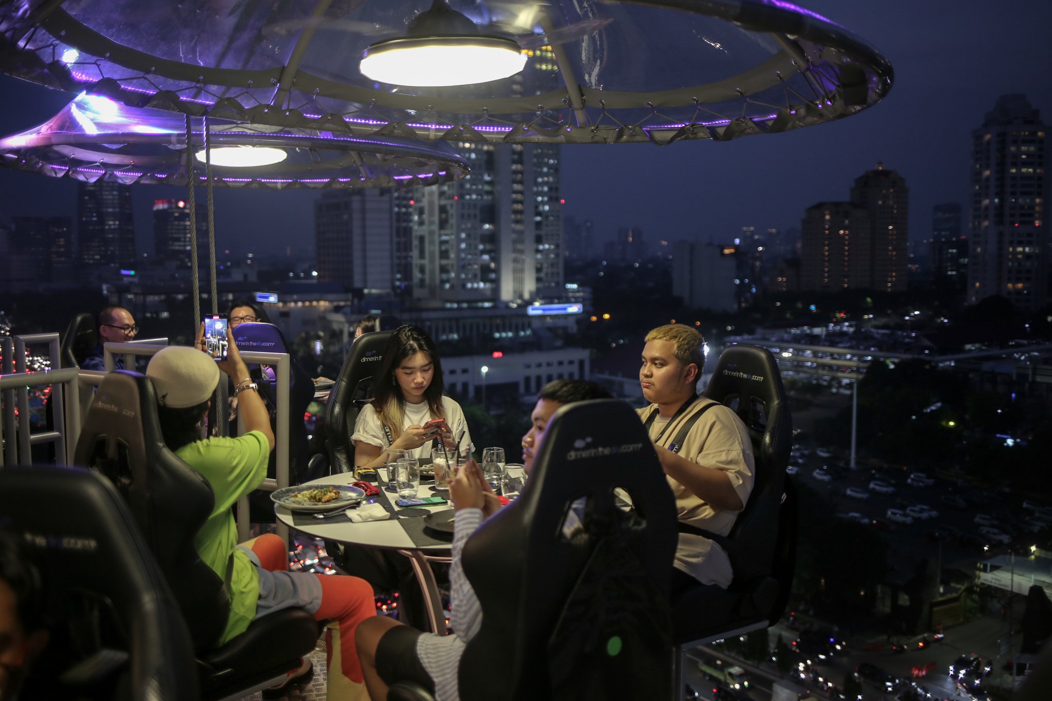 Pengunjung menyantap hidangan di Lounge in The Sky, Jakarta, Selasa (29/3/2022). Lounge in The Sky merupakan restoran yang menyajikan sensasi menyantap hidangan dari atas ketinggian dengan pemandangan cakrawala 360 derajat di pusat kota Jakarta dengan tingkat keamanan sesuai standar internasional yang tersertifikasi. Lounge in the sky mengudara setiap hari dari jam 17.00 hingga 21.00 WIB.