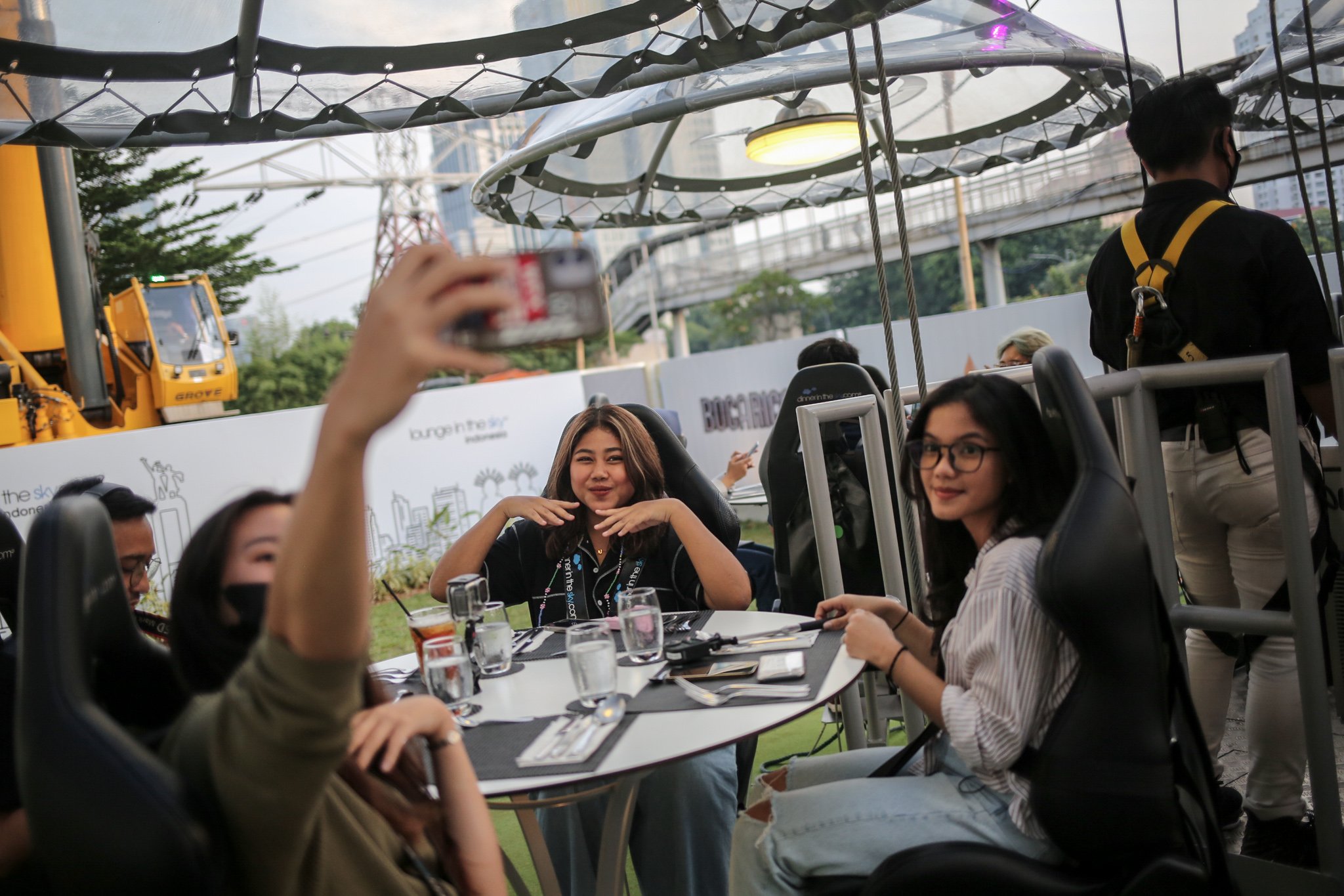 Pengunjung berswafoto di Lounge in The Sky, Jakarta, Selasa (29/3/2022). Lounge in The Sky merupakan restoran yang menyajikan sensasi menyantap hidangan dari atas ketinggian dengan pemandangan cakrawala 360 derajat di pusat kota Jakarta dengan tingkat keamanan sesuai standar internasional yang tersertifikasi. Lounge in the sky mengudara setiap hari dari jam 17.00 hingga 21.00 WIB.