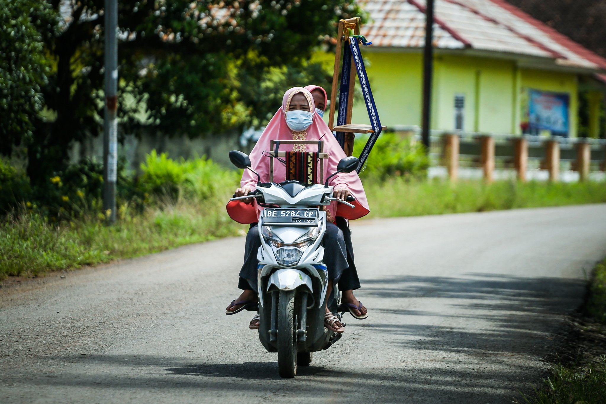 Nyai melintas menggunakan sepeda motor membawa tekang di Negeri Katon, Pesawaran, Lampung, Sumatera Selatan.