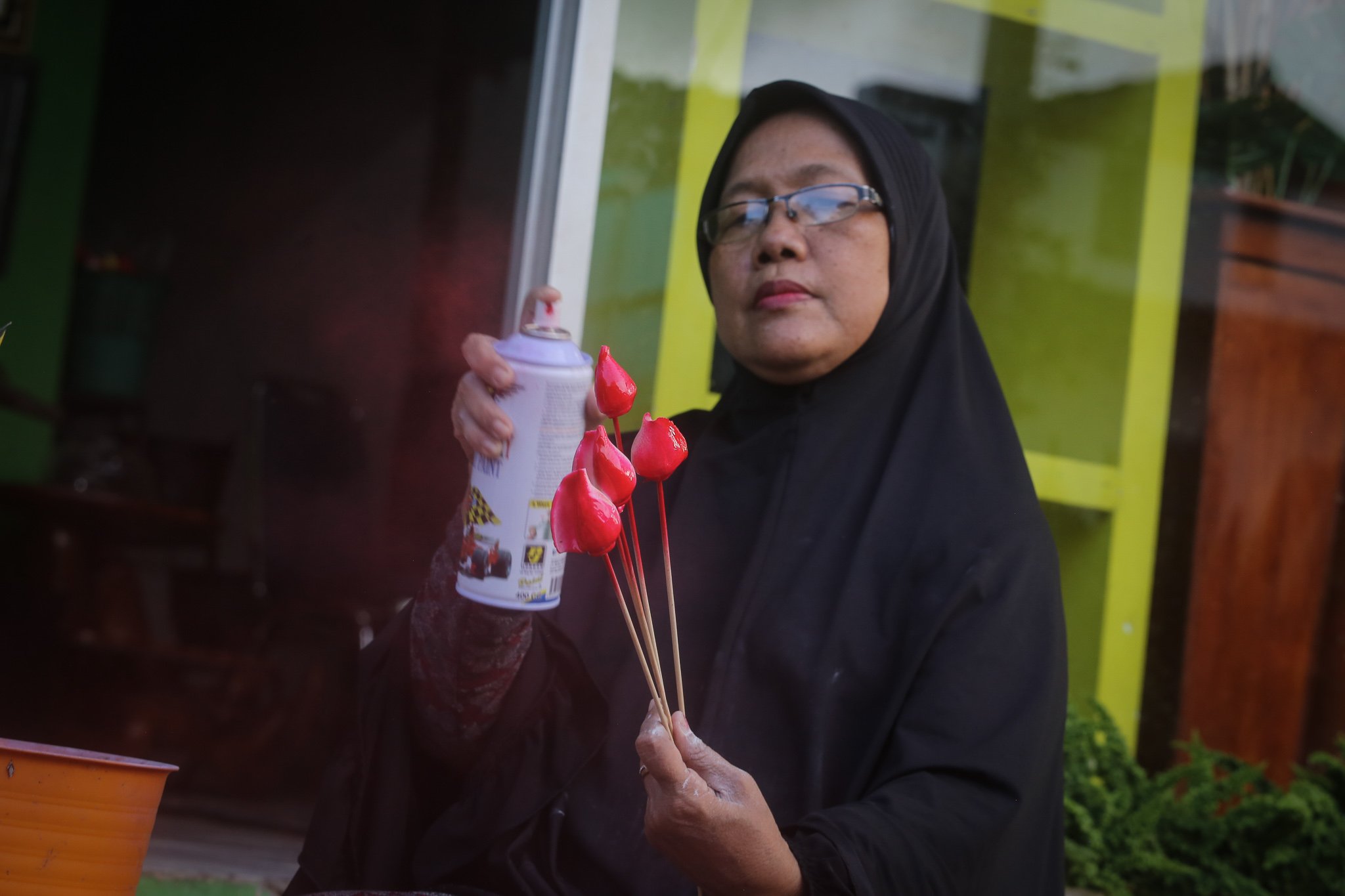 Suyanti mewarnai cangkang gonggong di UMKM Rumah Keong, Batam, Kepulauan Riau.