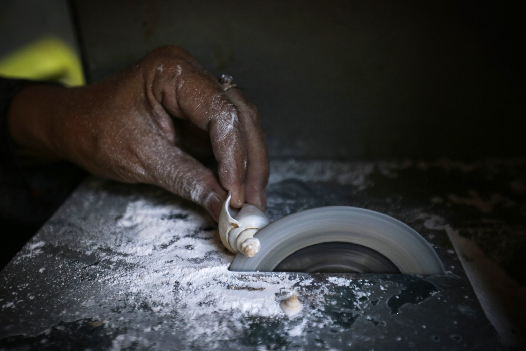 Perajin memotong cangkang gonggong dan mebetuknya sesuai pola yang diinginkan di UMKM Rumah Keong, Batam, Kepulauan Riau.