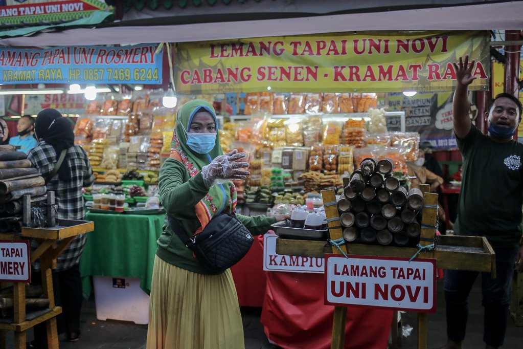 Pedagang menawarkan takjil berbuka puasa di Sentra kuliner Nasi Kapau di Jalan Kramat Raya, Senen, Jakarta Pusat, Selasa (12/4/2021). Menjelang berbuka puasa sentra kuliner yang menyajikan makanan khas sumatra barat ini selalu ramai dikunjungi pembeli.