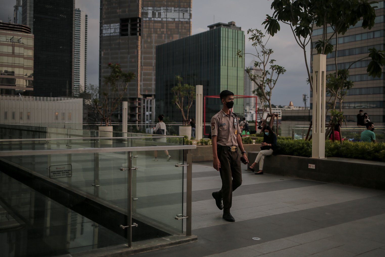 Petugas keamanan mengawasi pengunjung saat menanti waktu berbuka puasa di Sky Deck Sarinah, Jakarta, Senin (18/4/2022). Kawasan tersebut menjadi salah satu destinasi baru bagi warga Jakarta dan sekitarnya untuk menanti waktu berbuka puasa atau ngabuburit bersama keluarga dan kerabat.